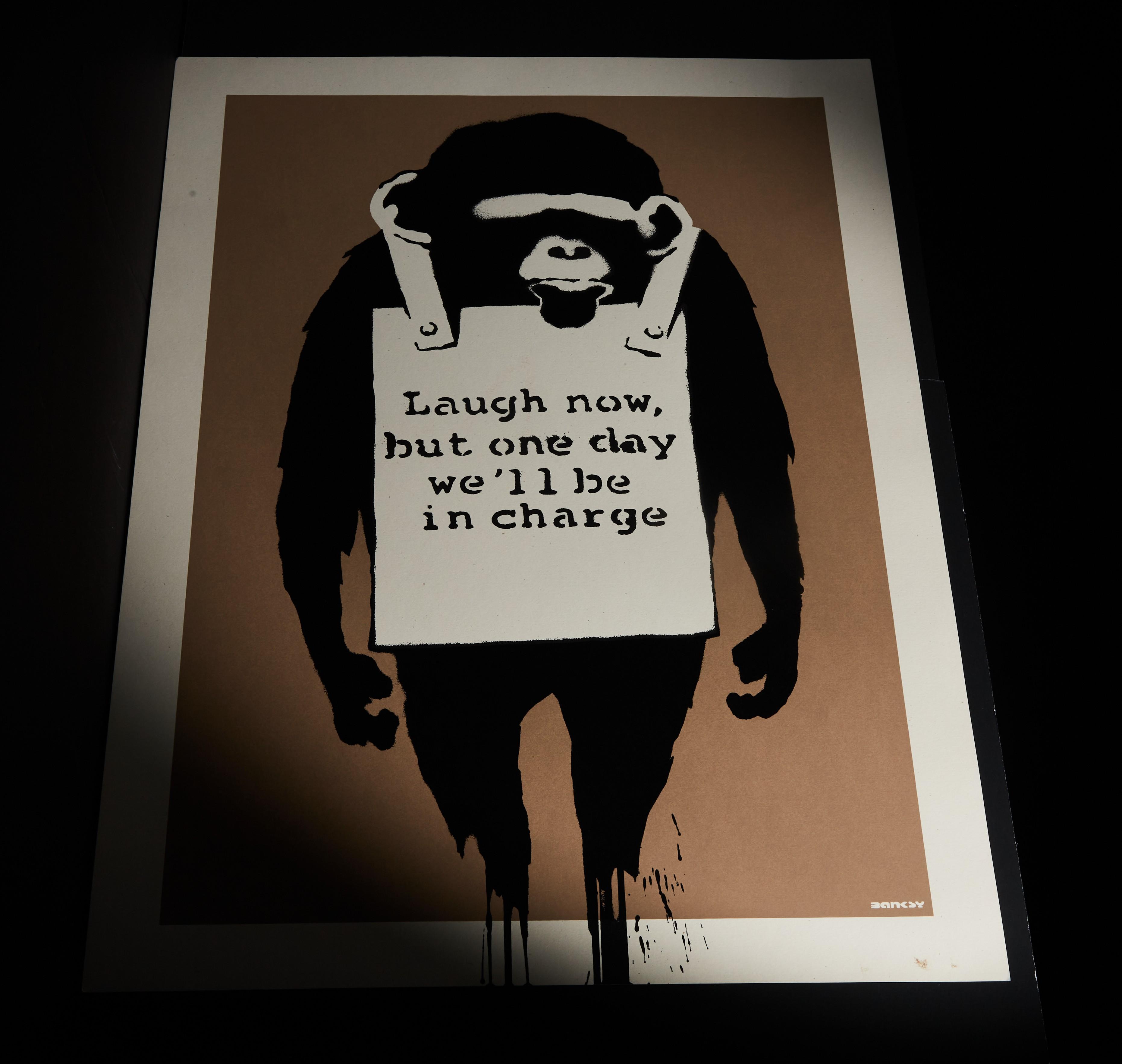 a poster of a chimpanzee holding a sign that says laugh now but one day we 'll be in charge