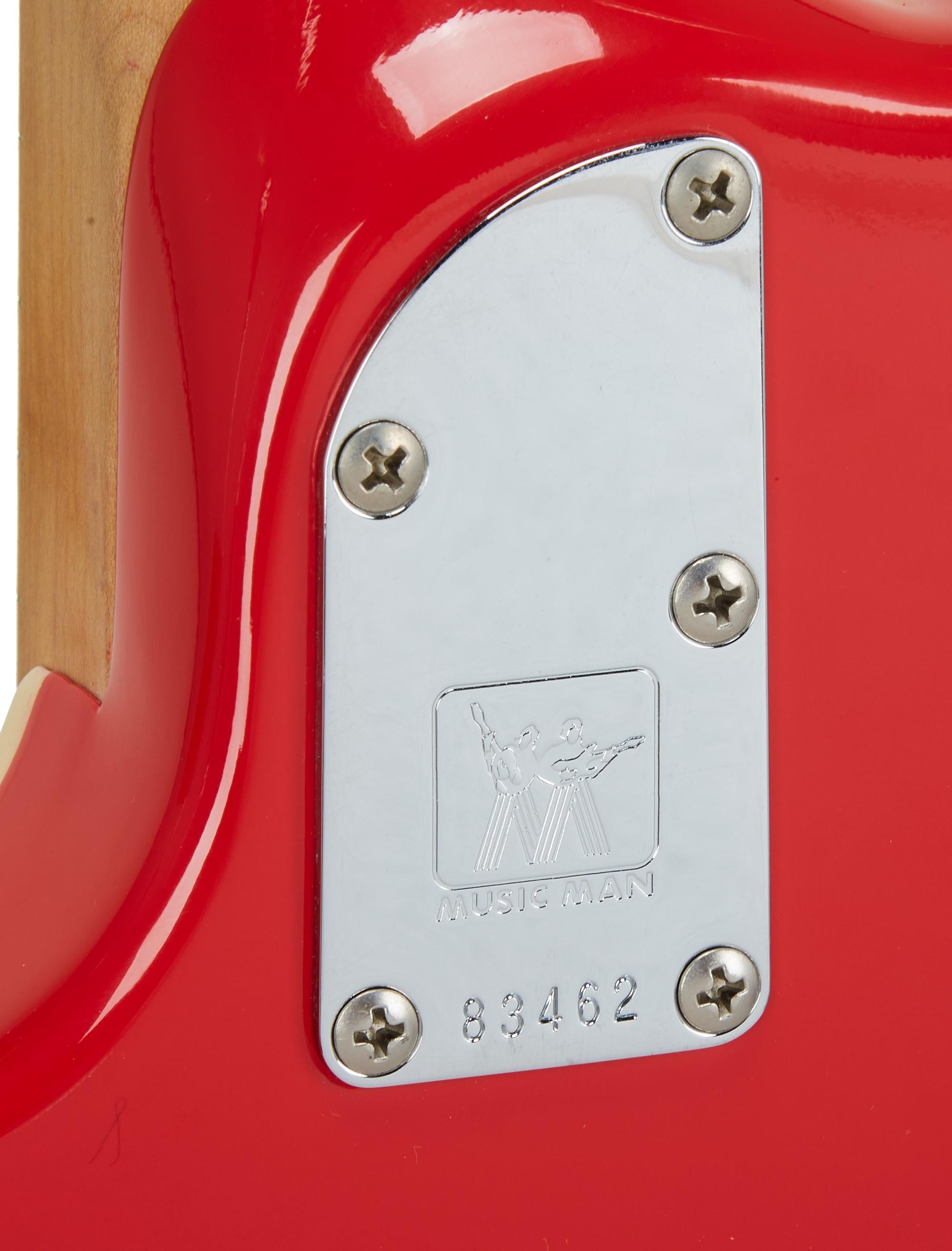 the back of a red electric guitar with the serial number 83482
