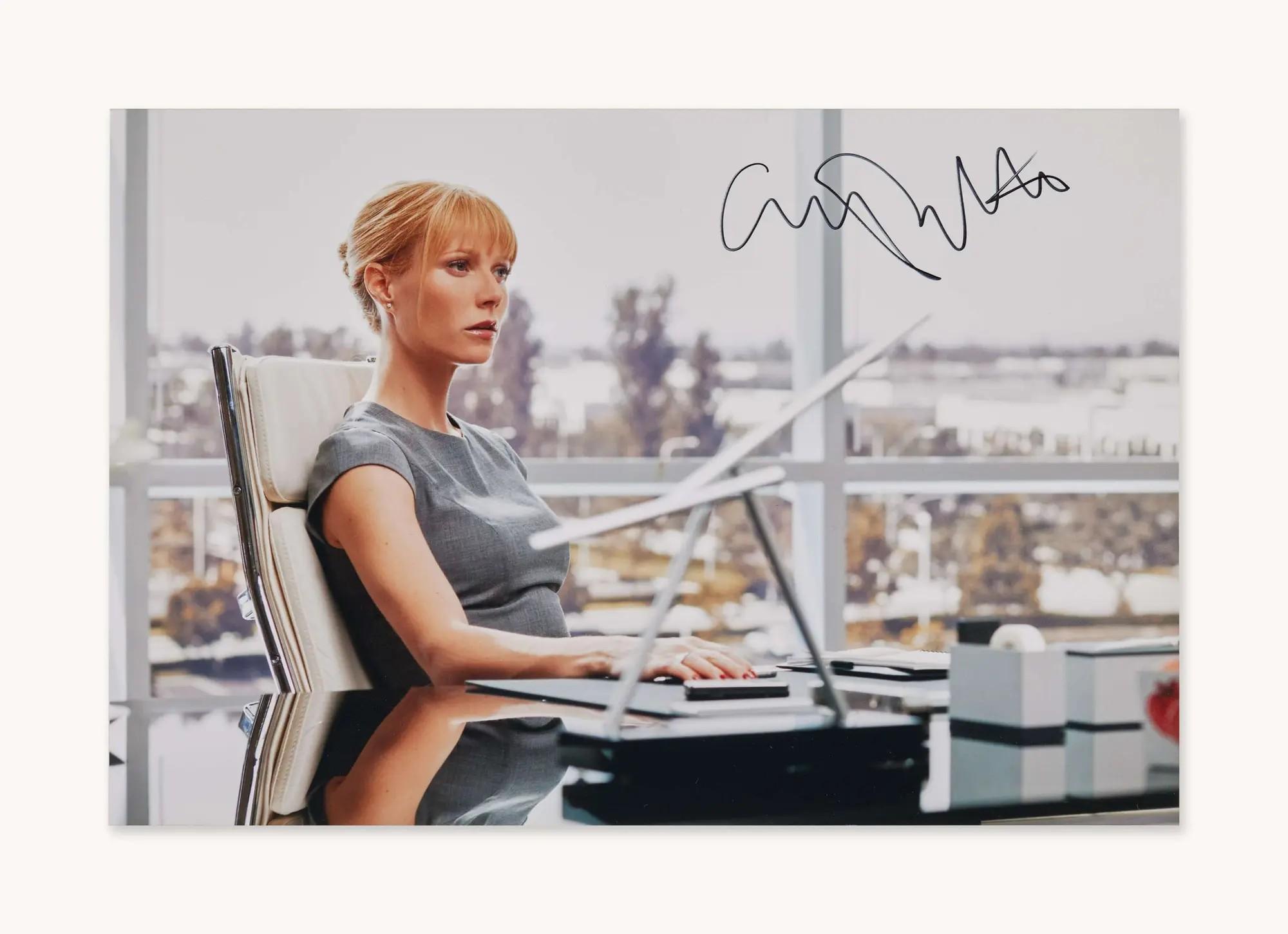 a signed photo of Gwyneth Paltrow sitting at a desk