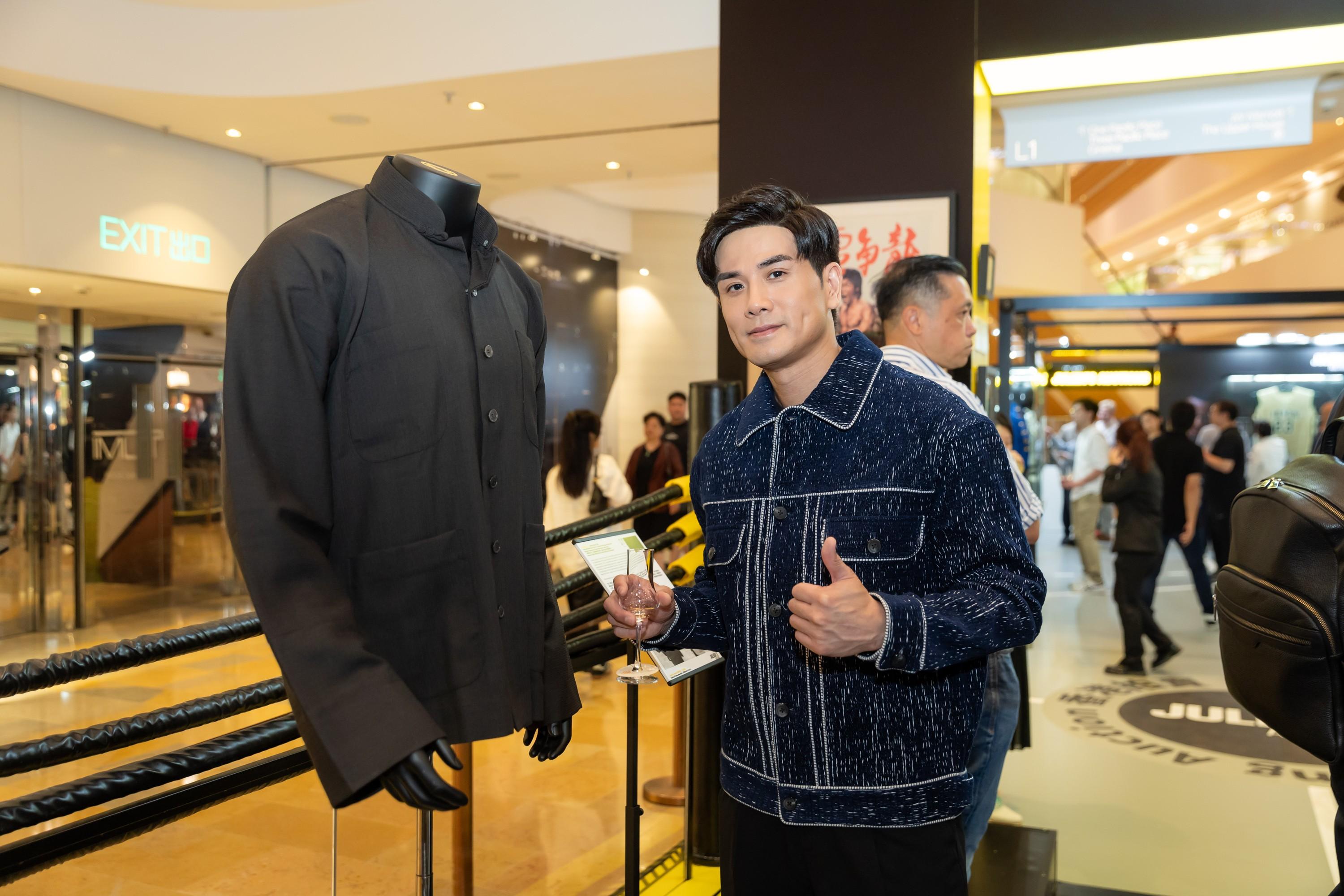 a man is standing in front of a mannequin in a store .