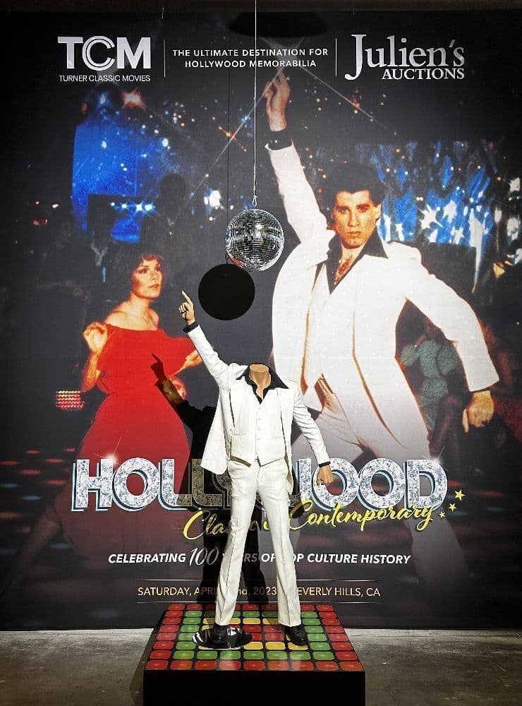a photo of a white tuxedo in front of a background photo of john travolta