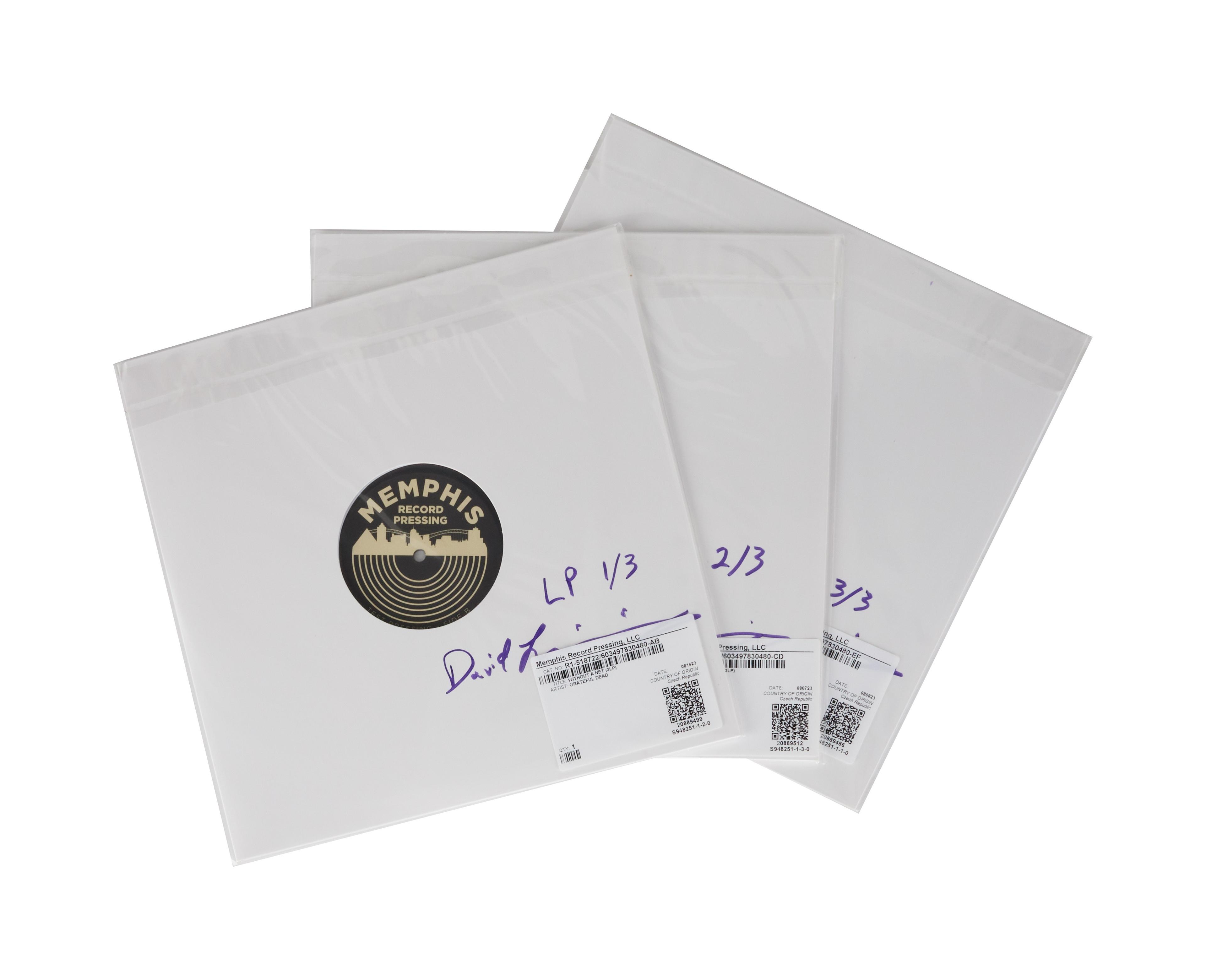 three white envelopes with labels on them are stacked on top of each other on a white background .