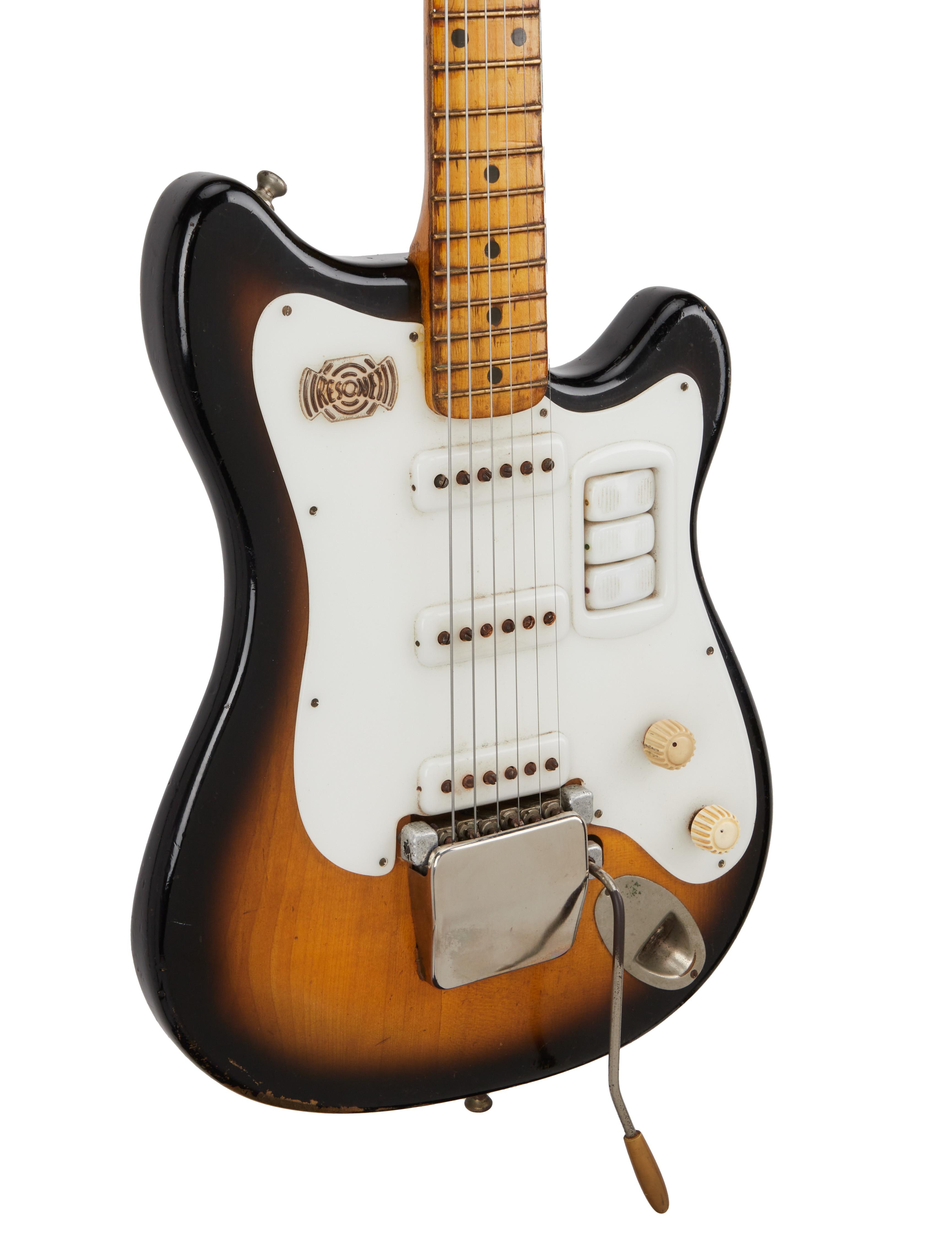a brown and white electric guitar with a white pickguard