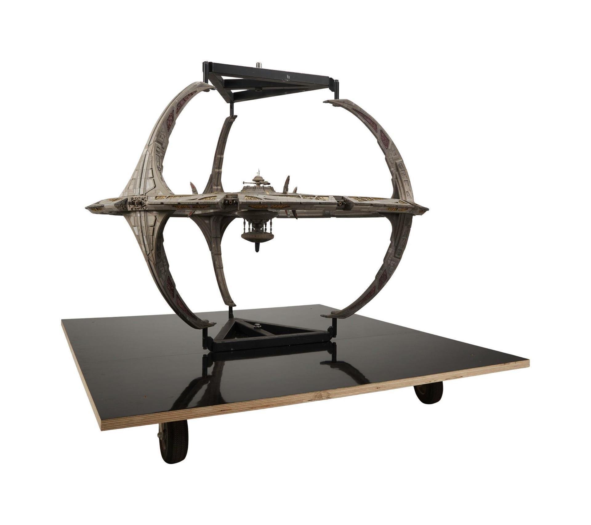 a model of a space ship is sitting on top of a wooden table .