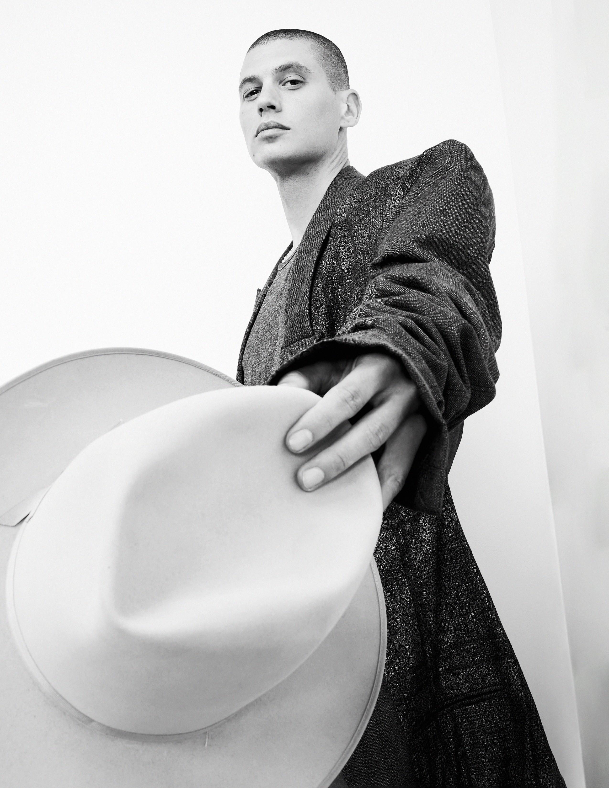 a man wearing a suit and holding a hat