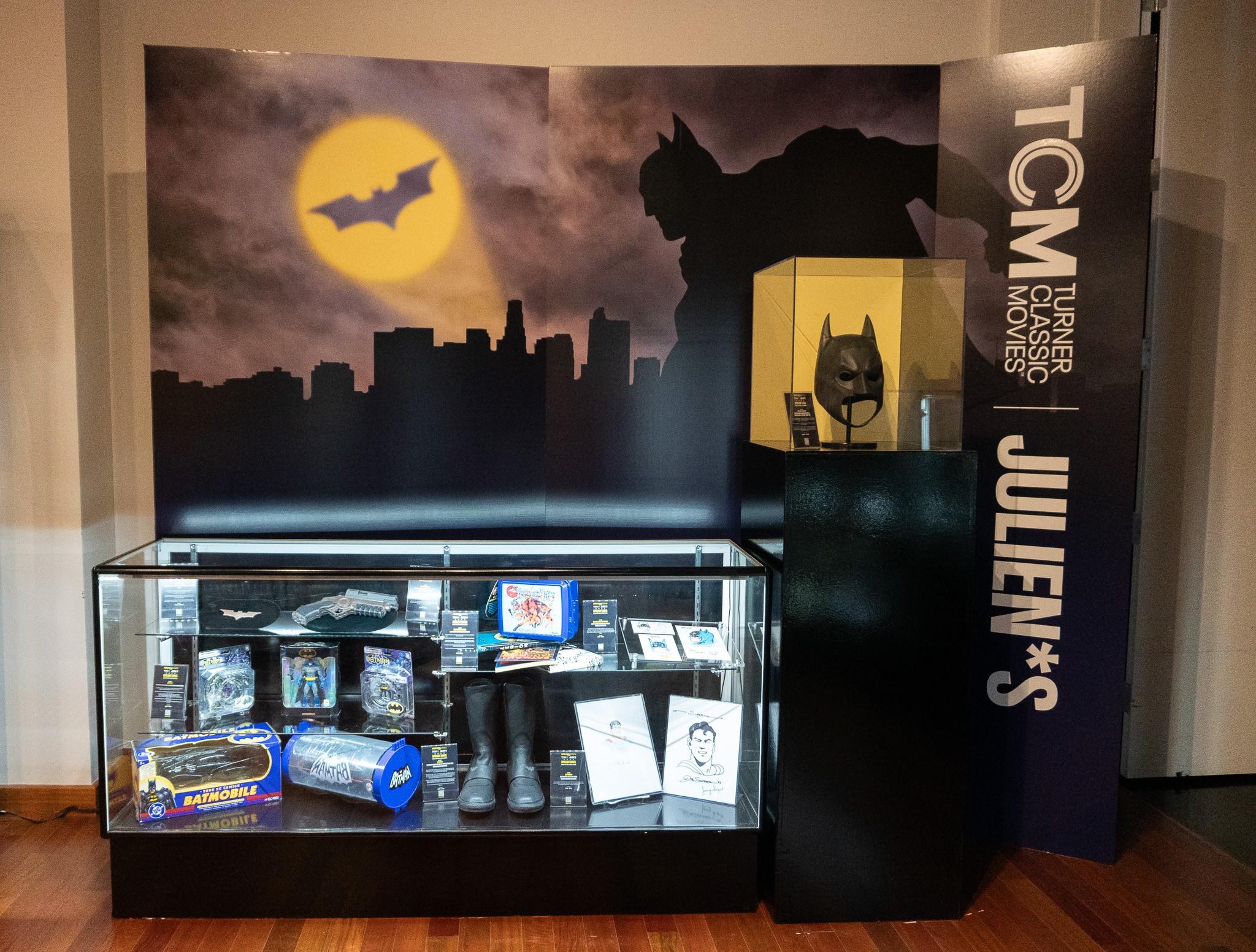 there is a display case with a batman mask on it .