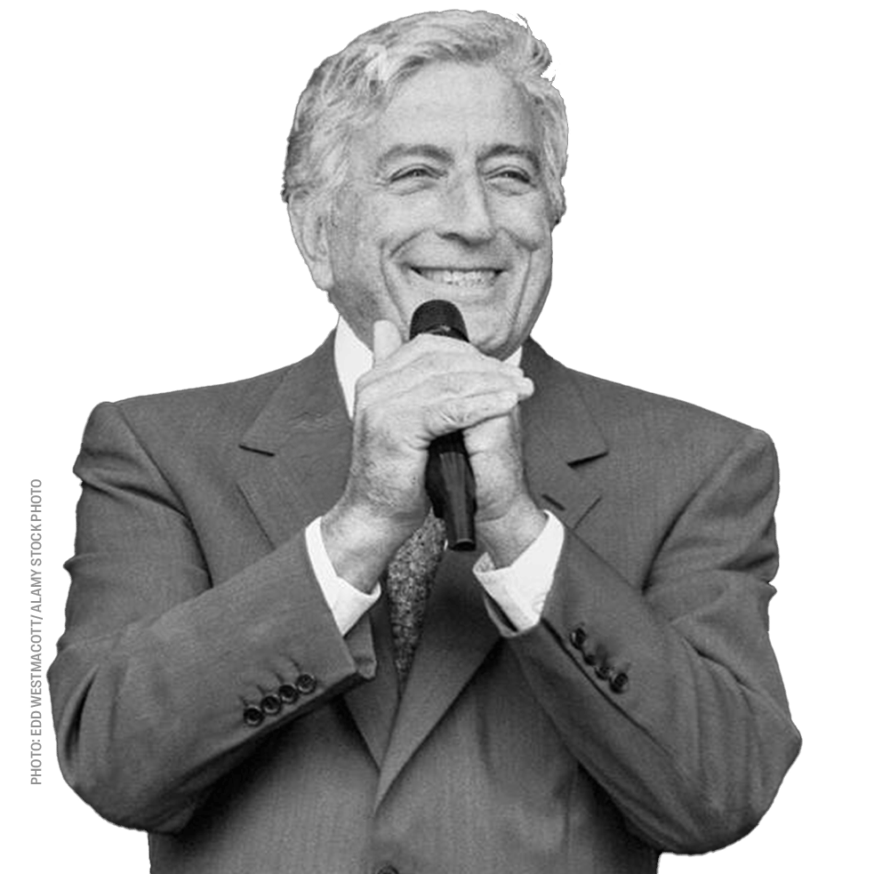 a man in a suit is smiling while holding a microphone