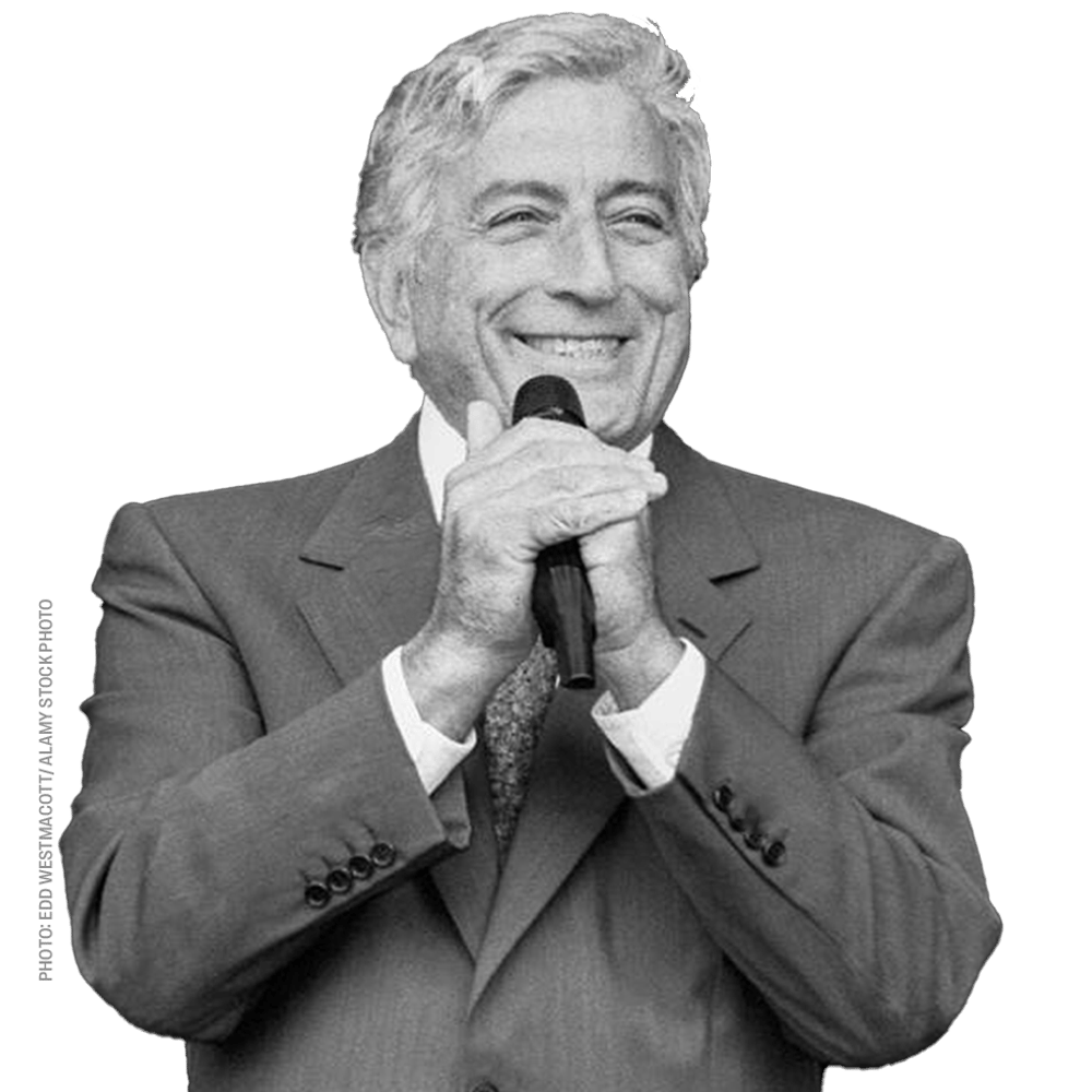 a man in a suit is smiling while holding a microphone