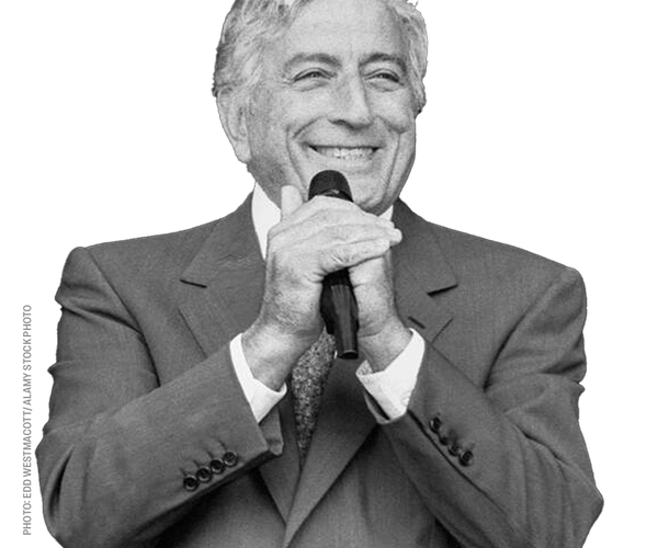 a man in a suit is smiling while holding a microphone