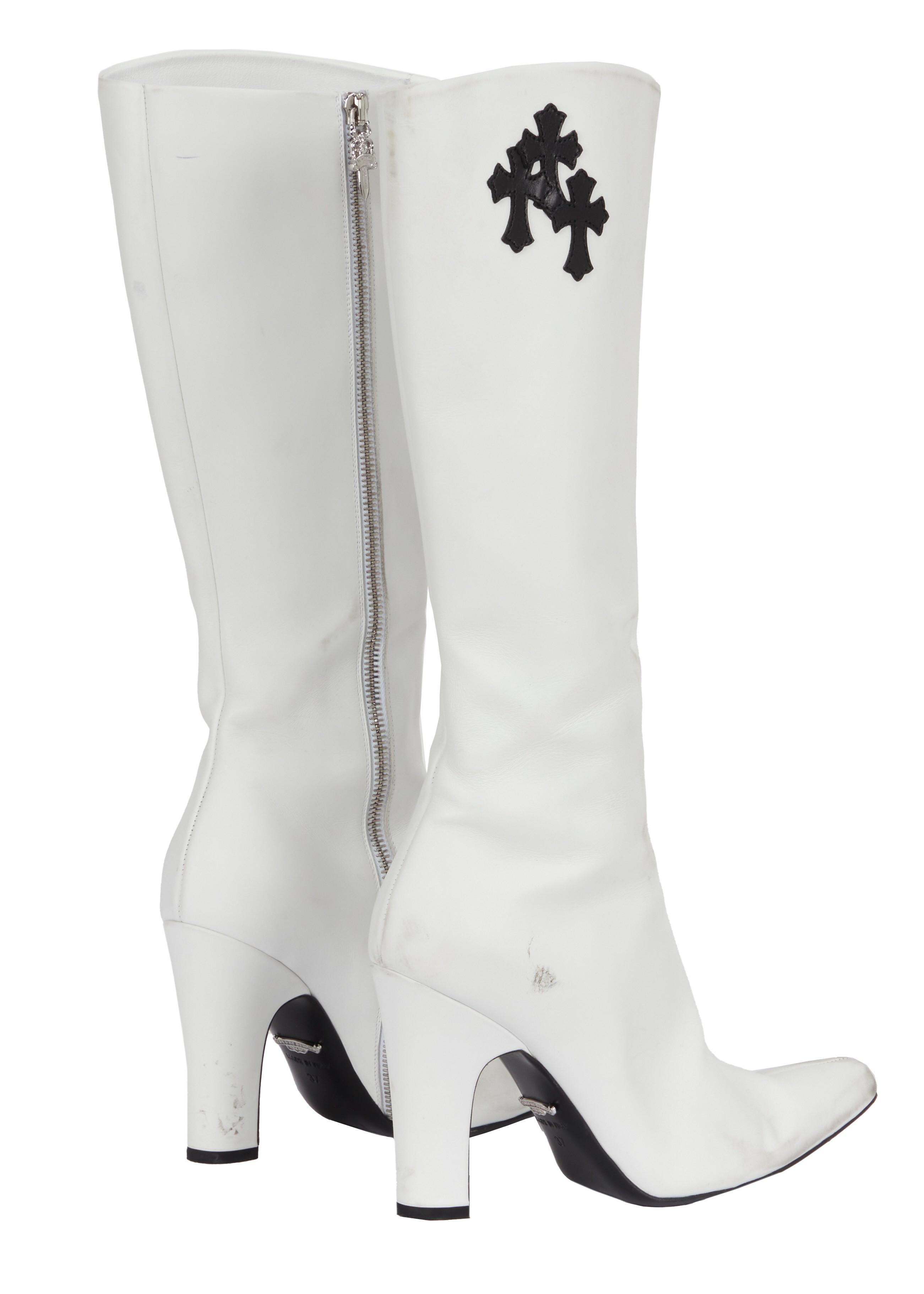 a pair of white boots with a black cross on the side