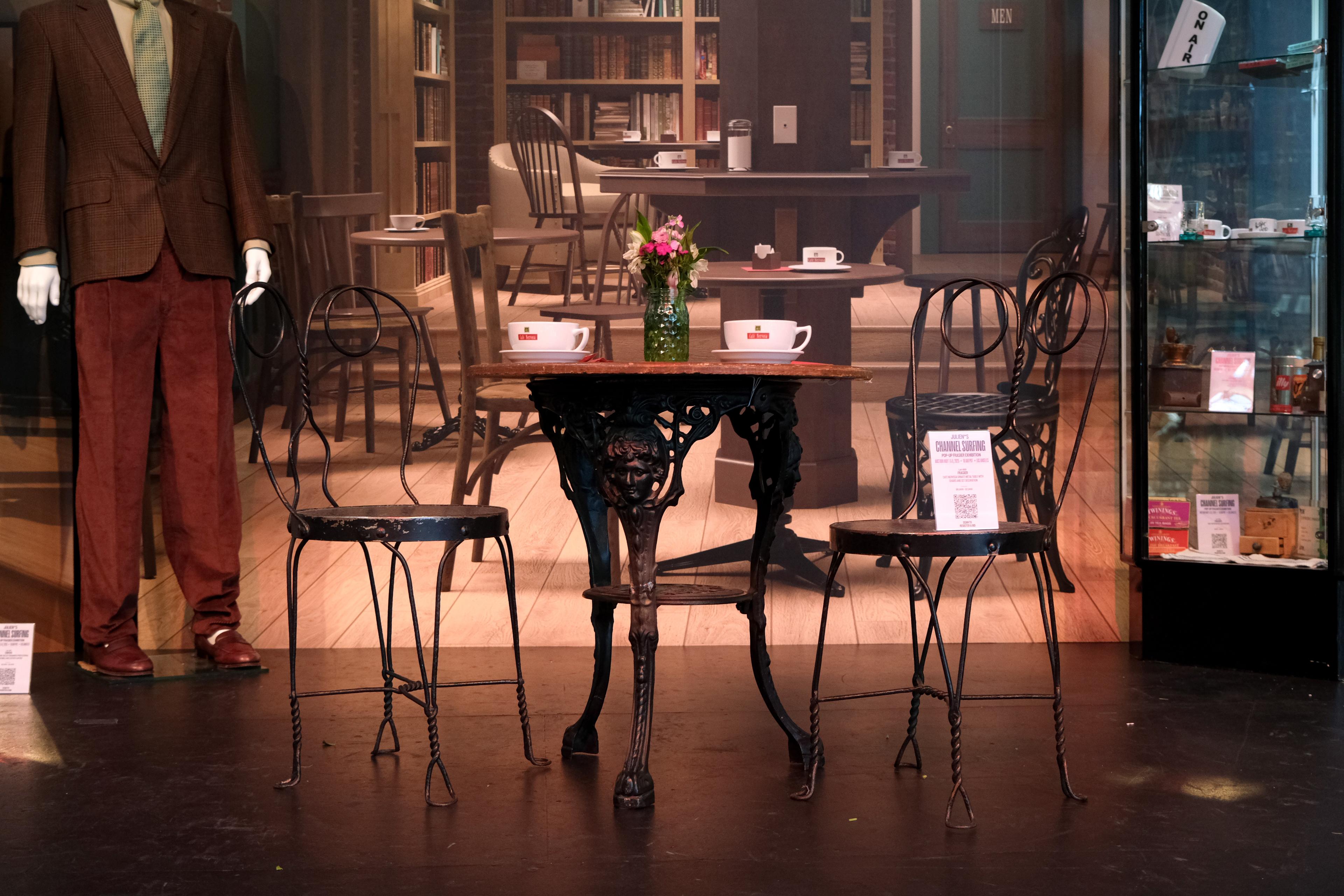 a table and chairs amid a coffee house back drop