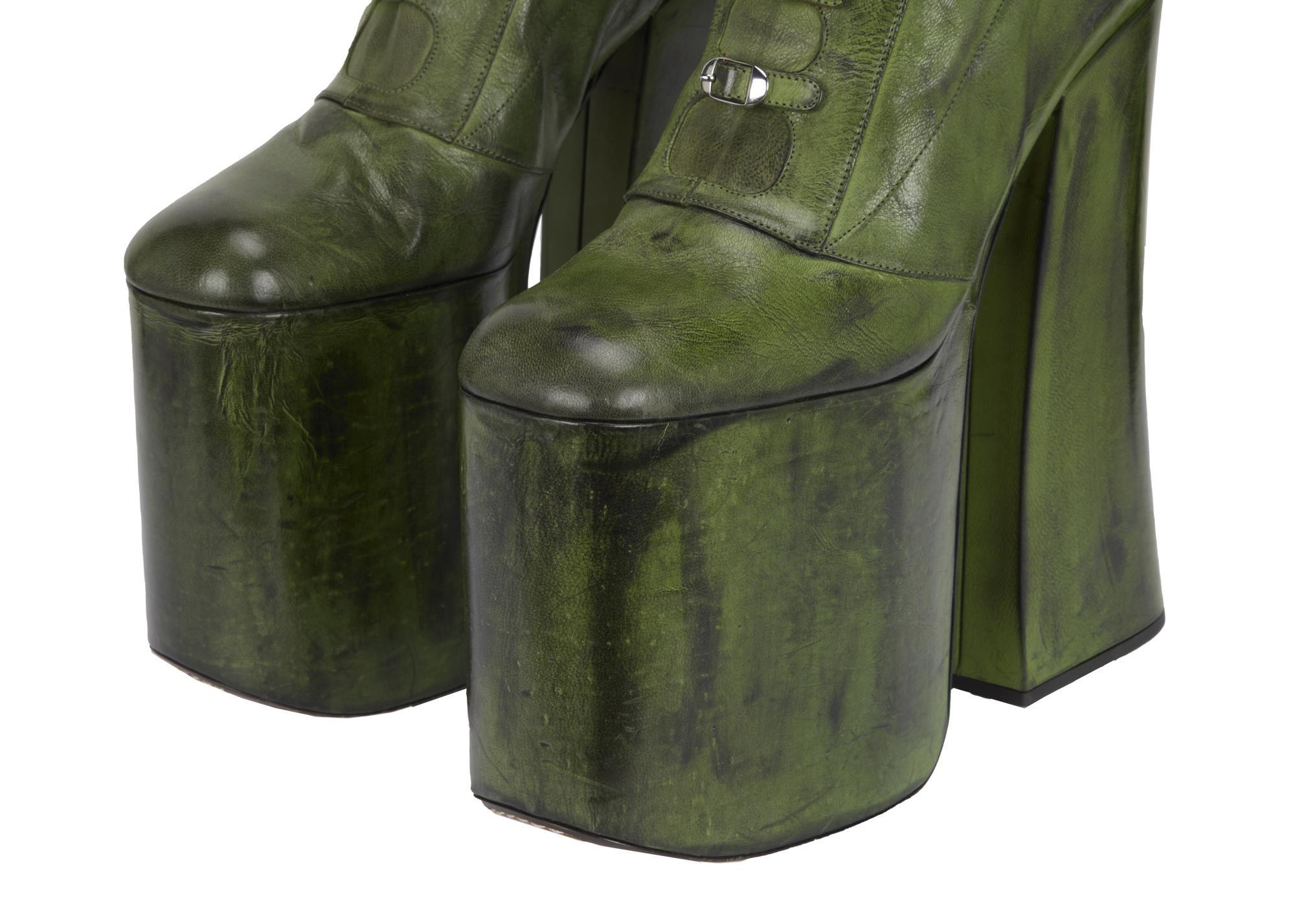 a pair of green leather platform boots on a white background .