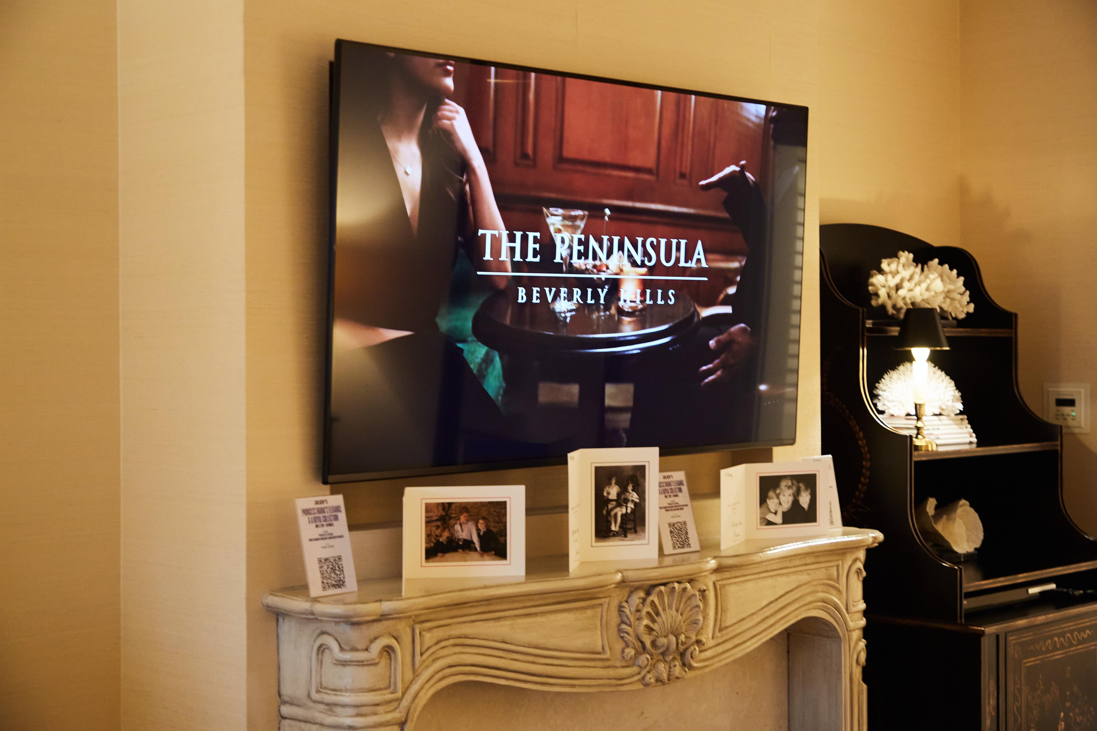 a flat screen tv is hanging on the wall above a fireplace .