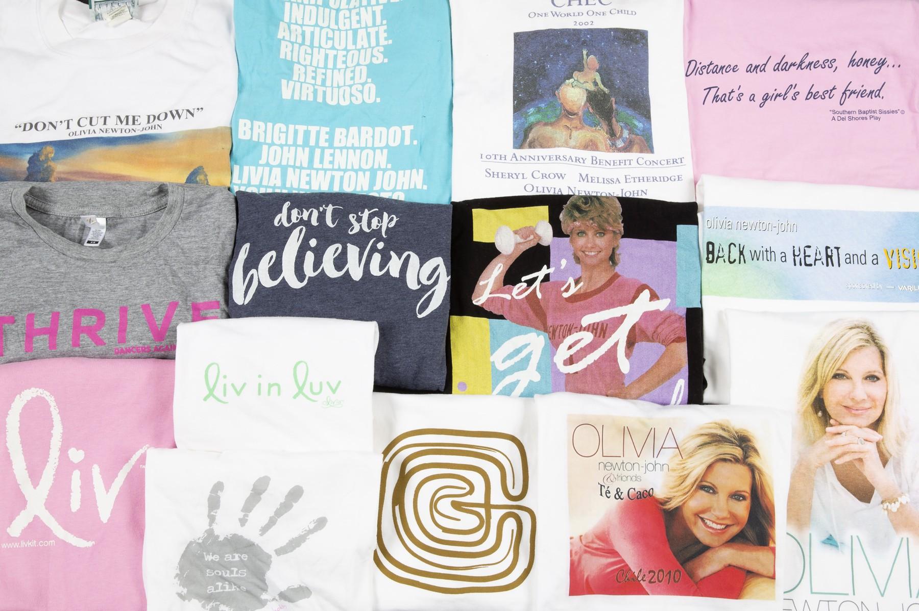 a bunch of t-shirts are sitting on top of each other on a table .