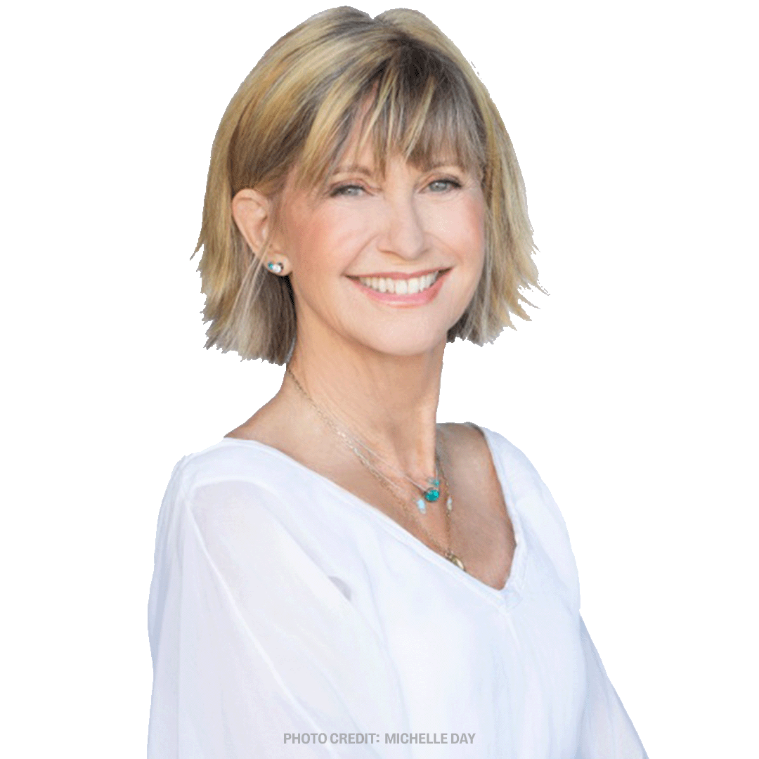 a woman wearing a white shirt and a necklace smiles for the photo credit michelle day