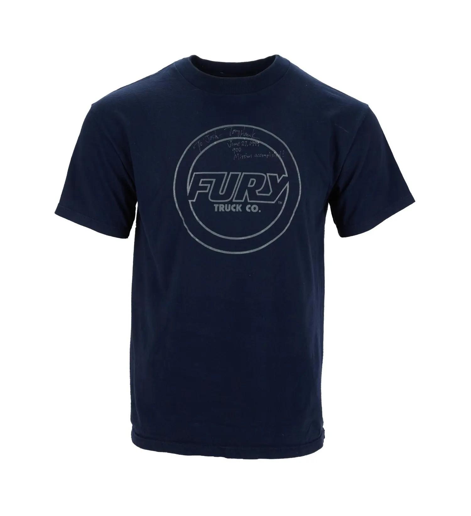 Lot #39. Tony Hawk | Signed and Worn 1999 X Games "900" T-Shirt with Signed Poster A navy blue t-shirt featuring a gray "FURY TRUCK CO." logo within a circle, with faint handwritten text above.