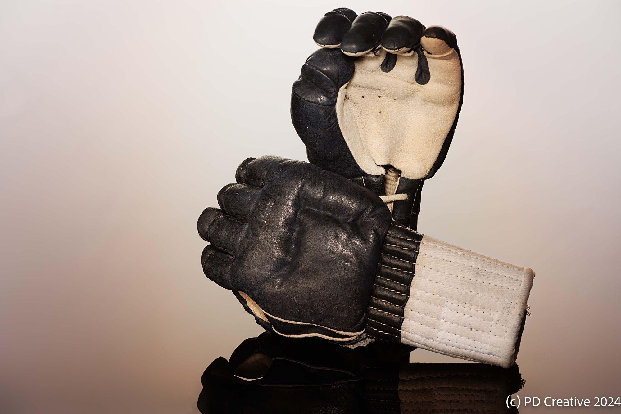 a pair of black and white boxing gloves are stacked on top of each other .