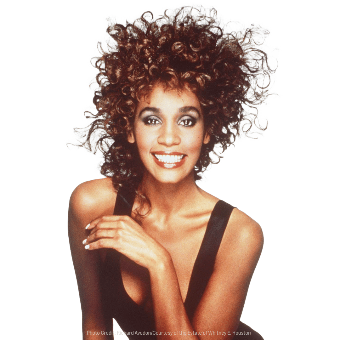 a photo of a woman with curly hair is credited to the estate of whitney e. houston