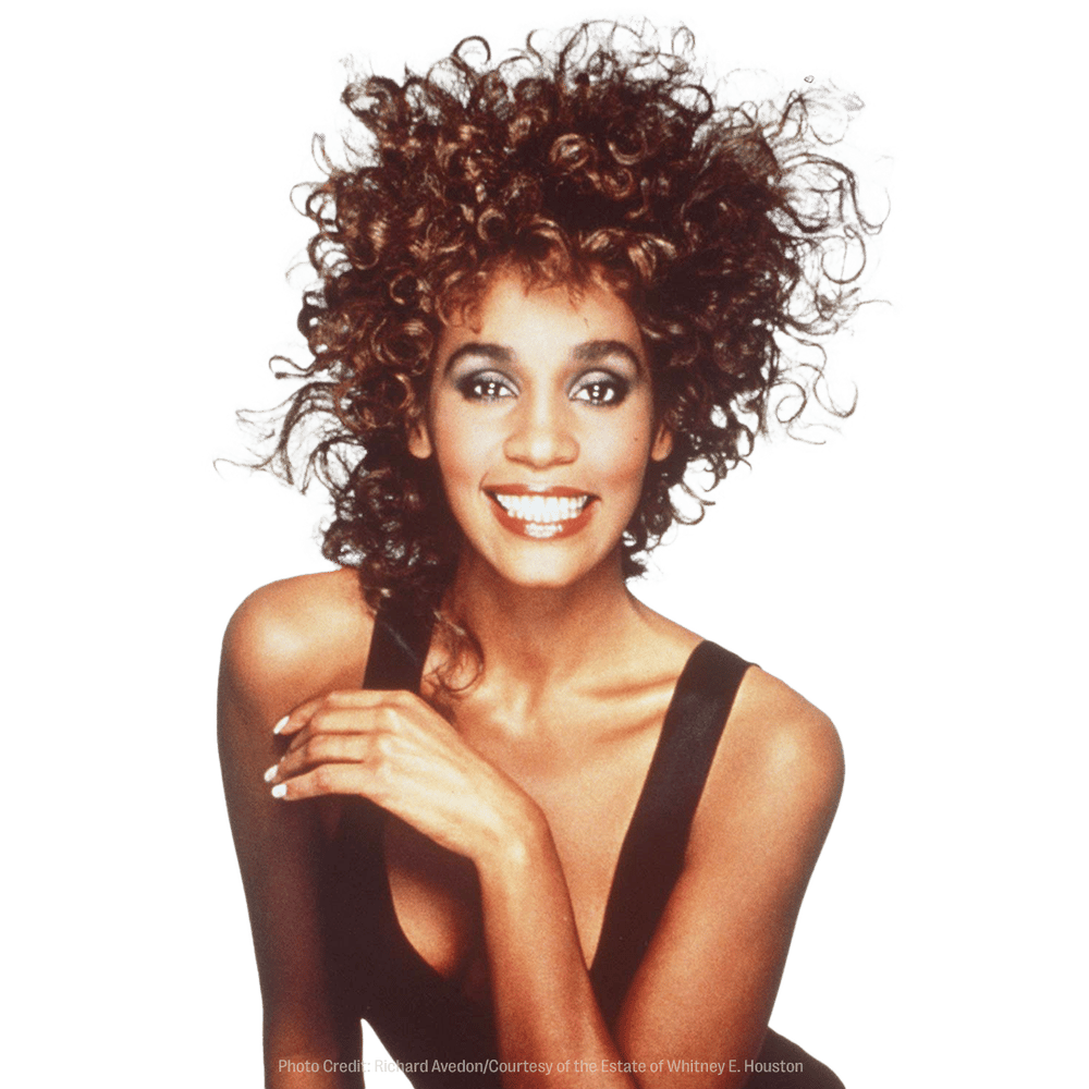 a photo of a woman with curly hair is credited to the estate of whitney e. houston