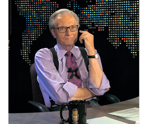 A photo of Larry king at his desk