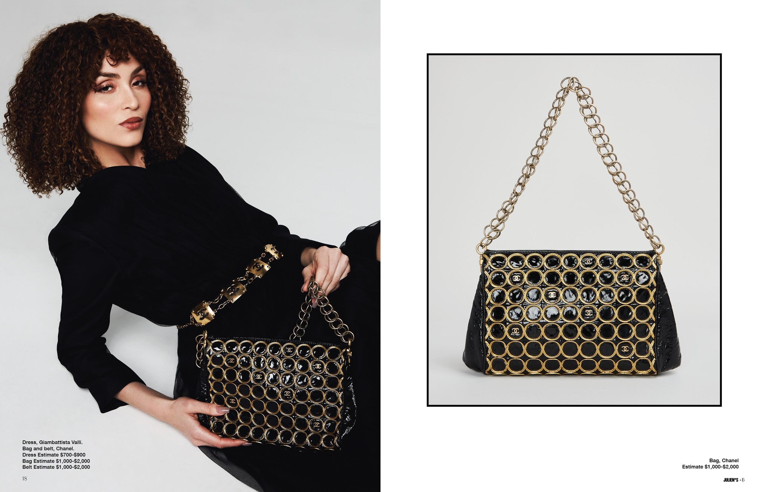 a woman in a black dress is holding a black purse with gold chains .
