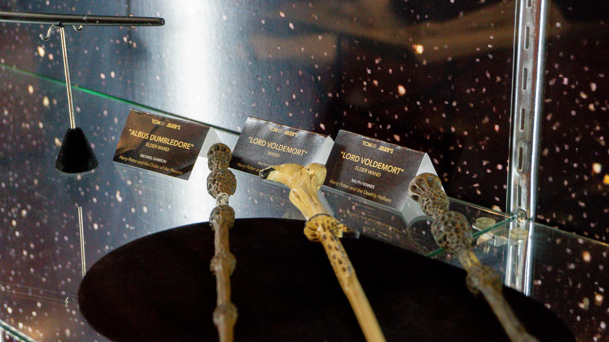 three wands are on display in a glass case .