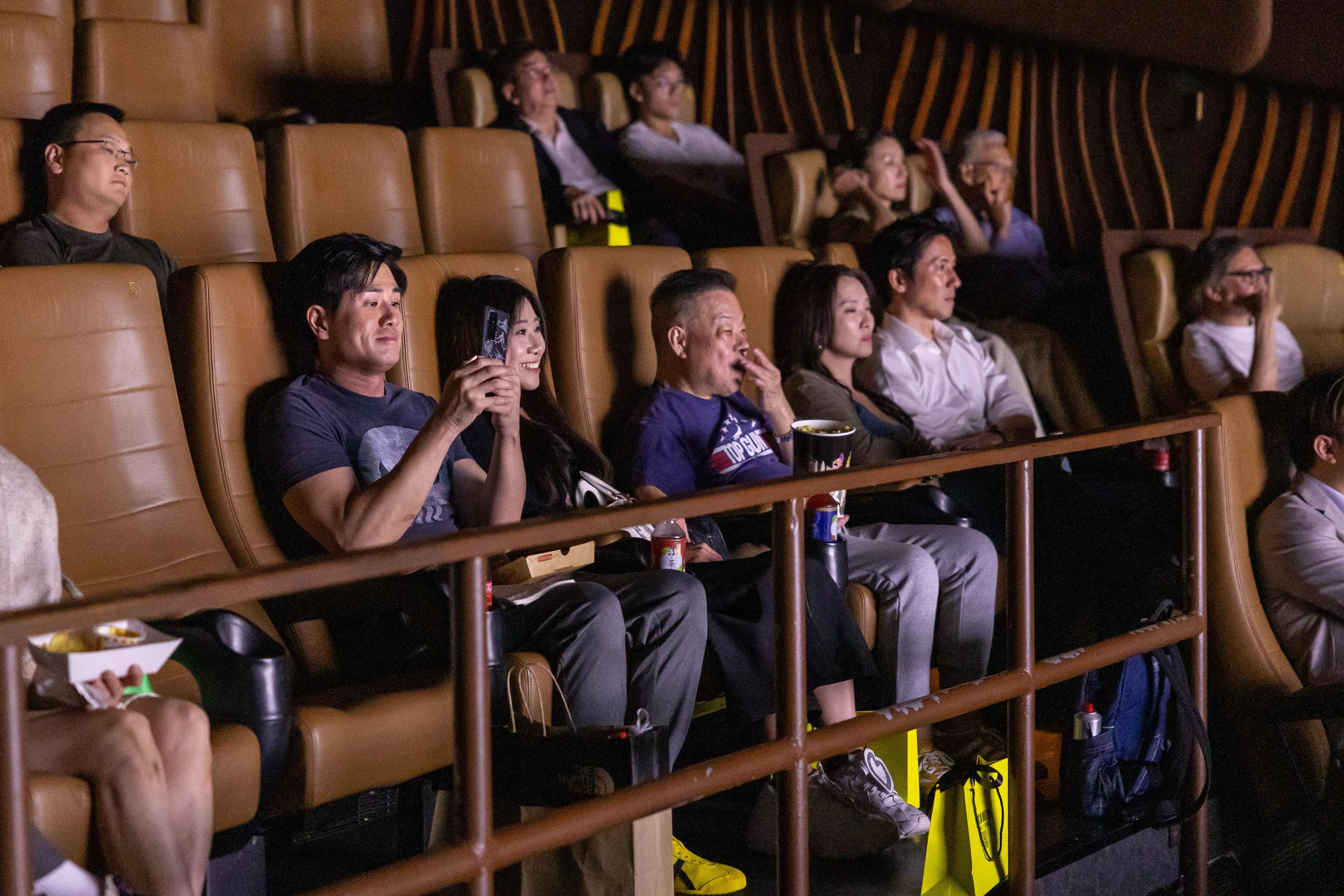 a group of people are sitting in a movie theater watching a movie .