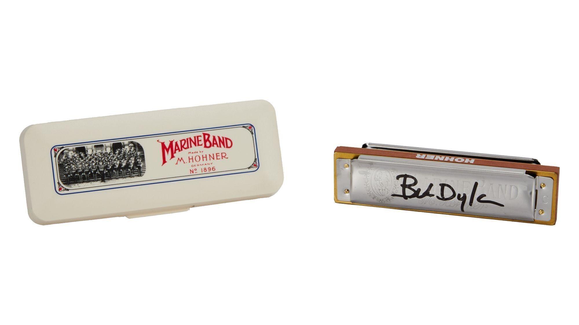 a harmonica in a case next to a harmonica on a white background .