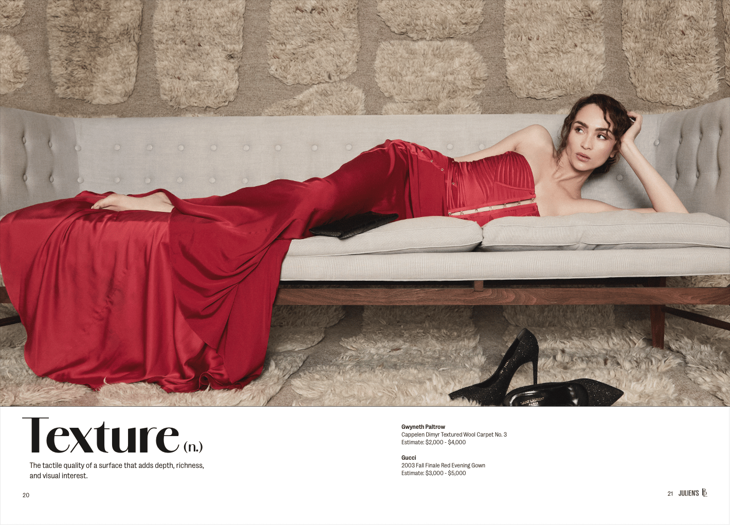 a model is wearing a red dress while saying on a bone colored couch with a textured beige colored rug set as the backdrop