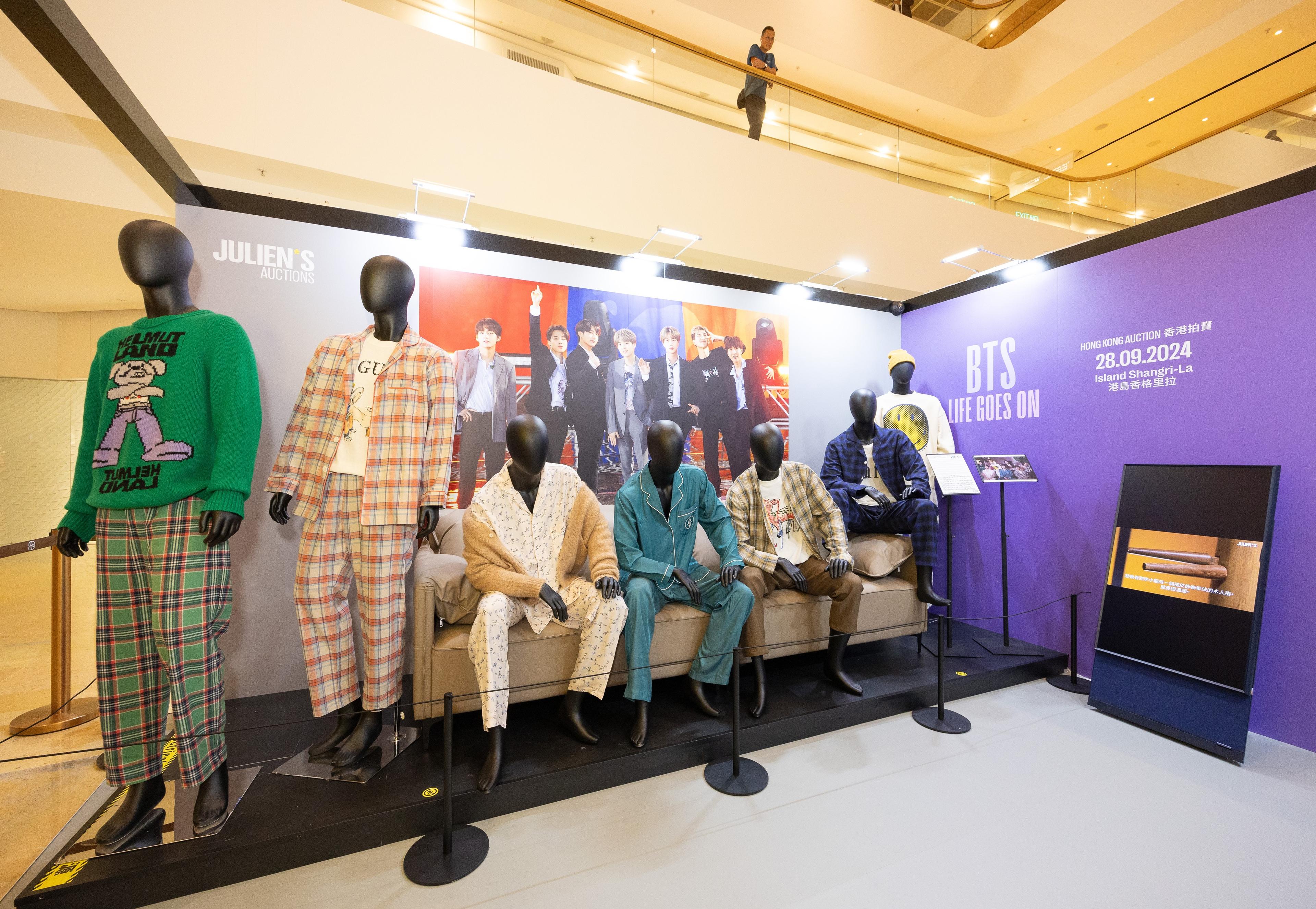 a group of mannequins are sitting on a couch in a room .