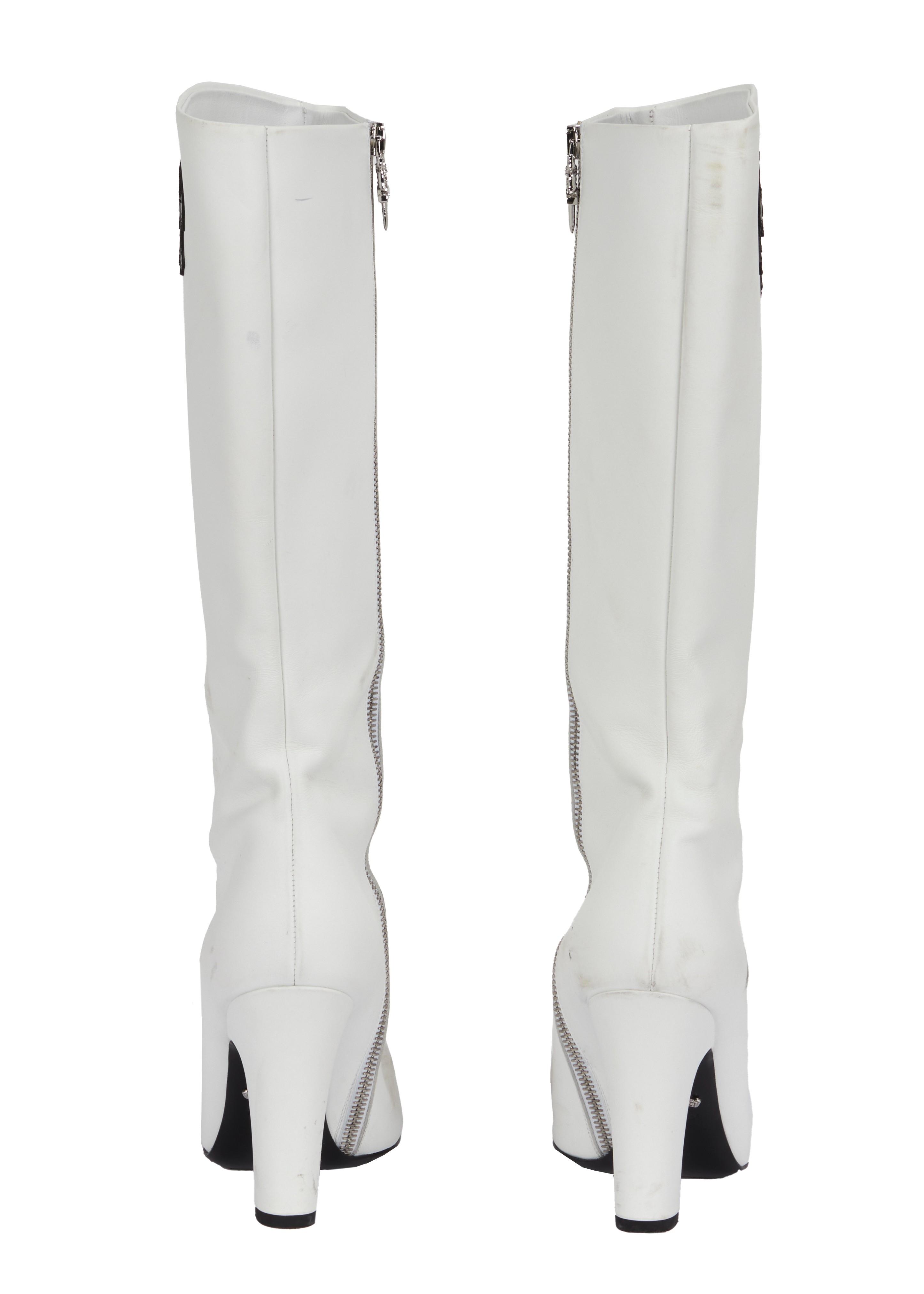 a pair of white boots with a zipper on the side