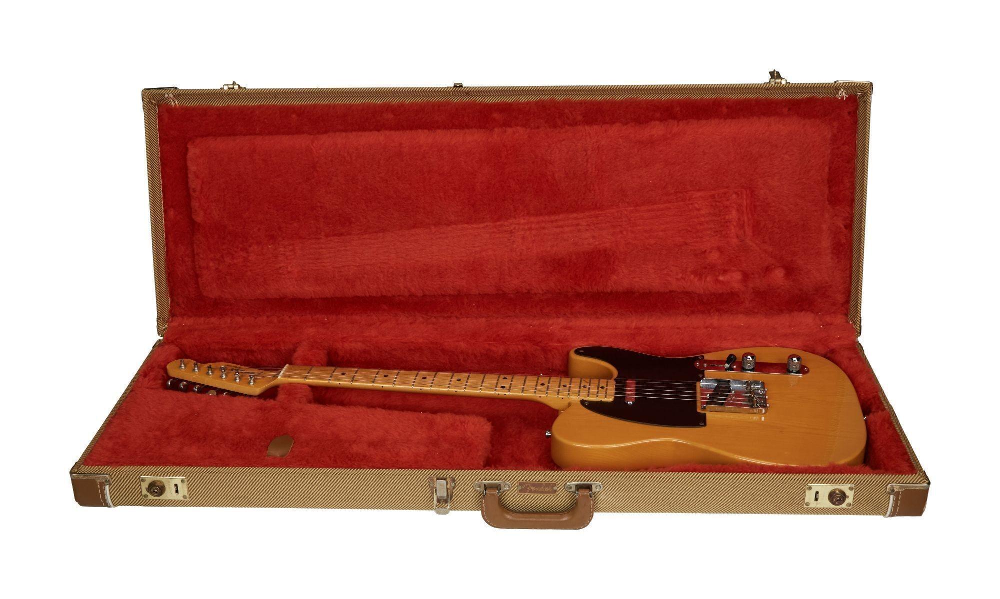 a guitar is sitting in a red case on a white background .