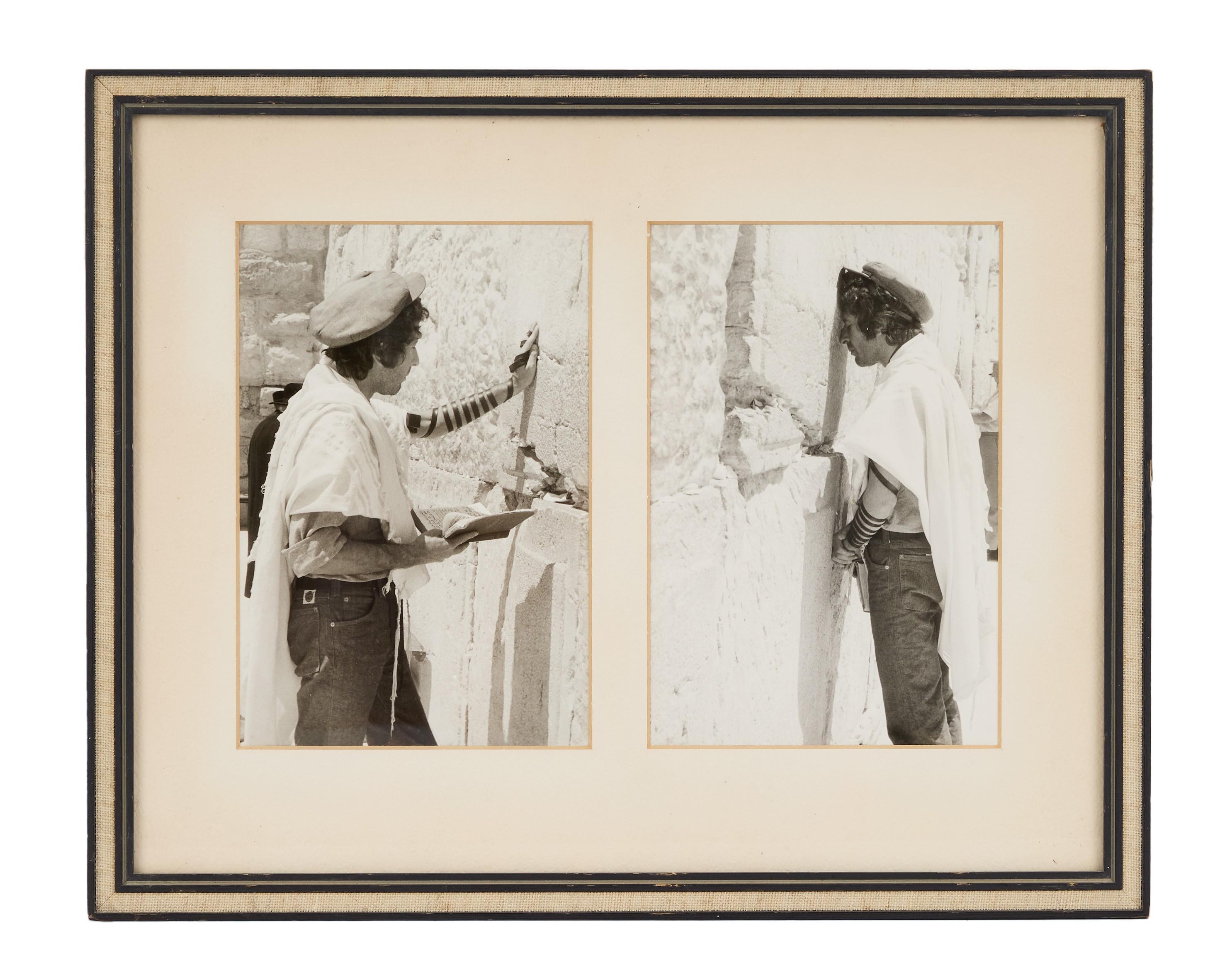 a black and white photo of leonard cohen praying at the western wall .