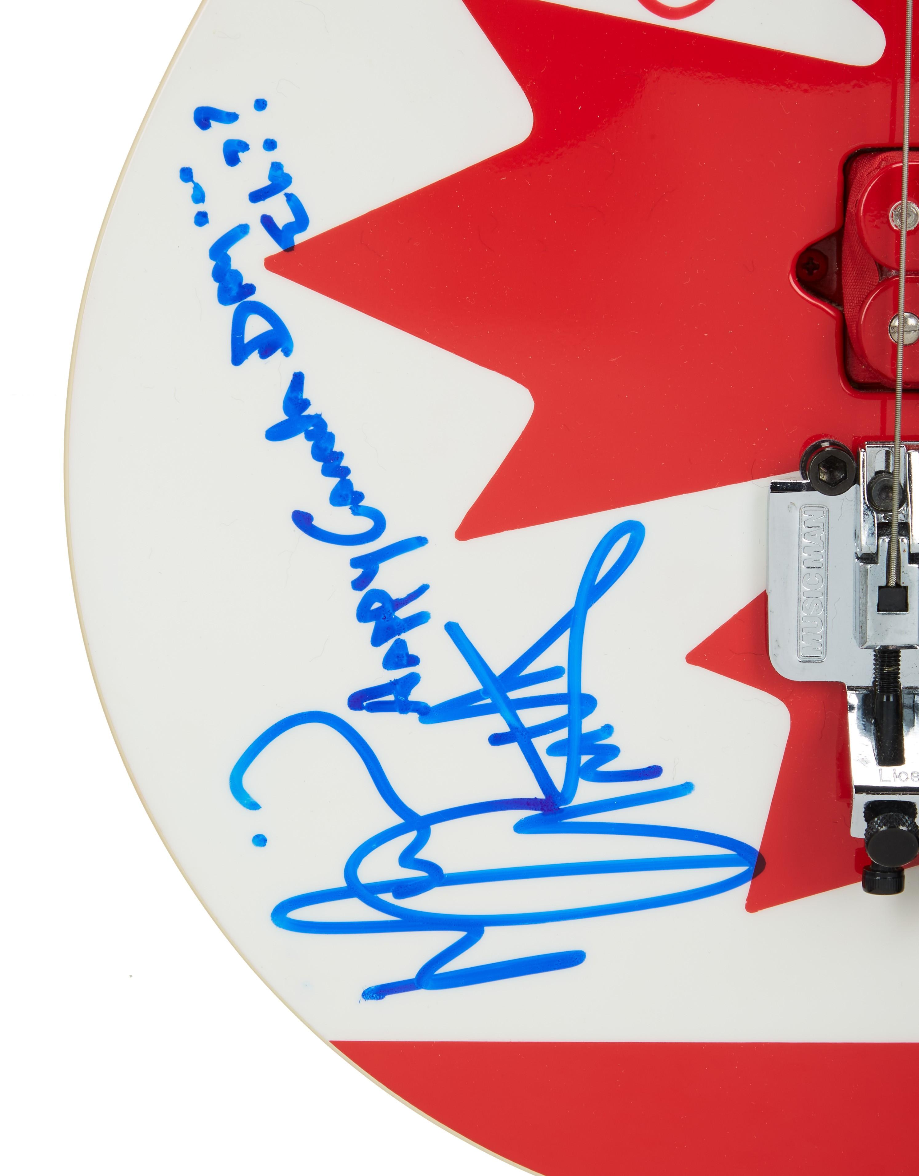 a red and white guitar has a signature on it