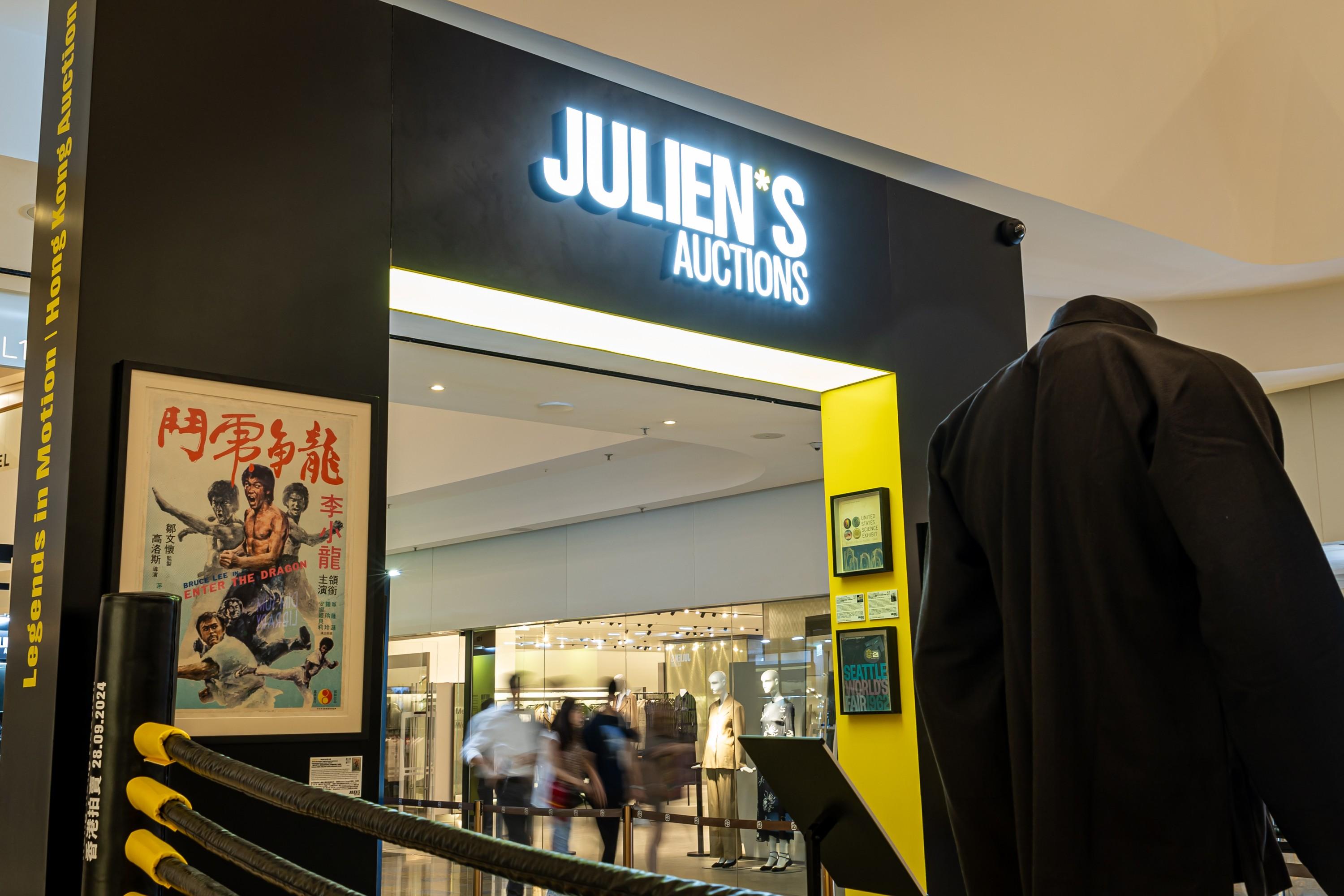 a mannequin is standing in front of a store called julien 's auctions .