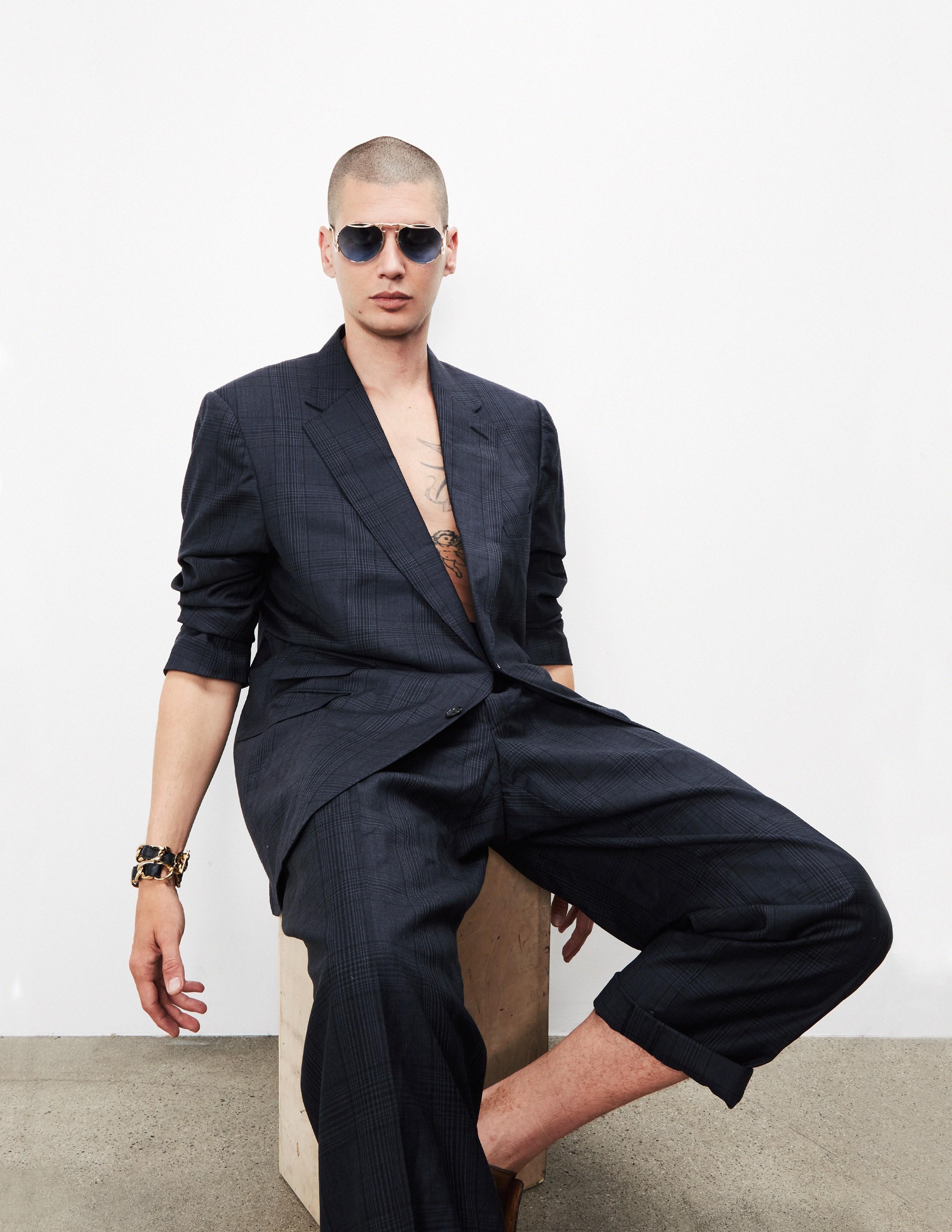 a man posing wearing a suit