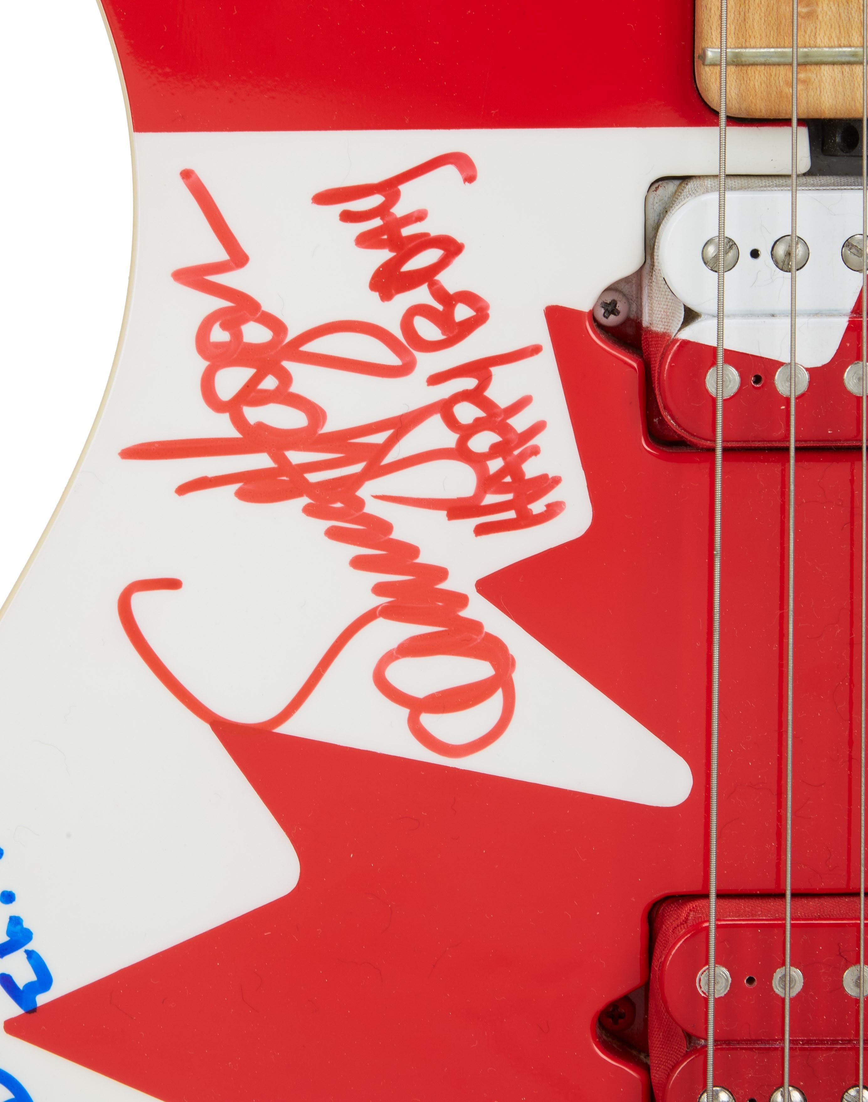a red and white guitar with a sticker that says heavy metal