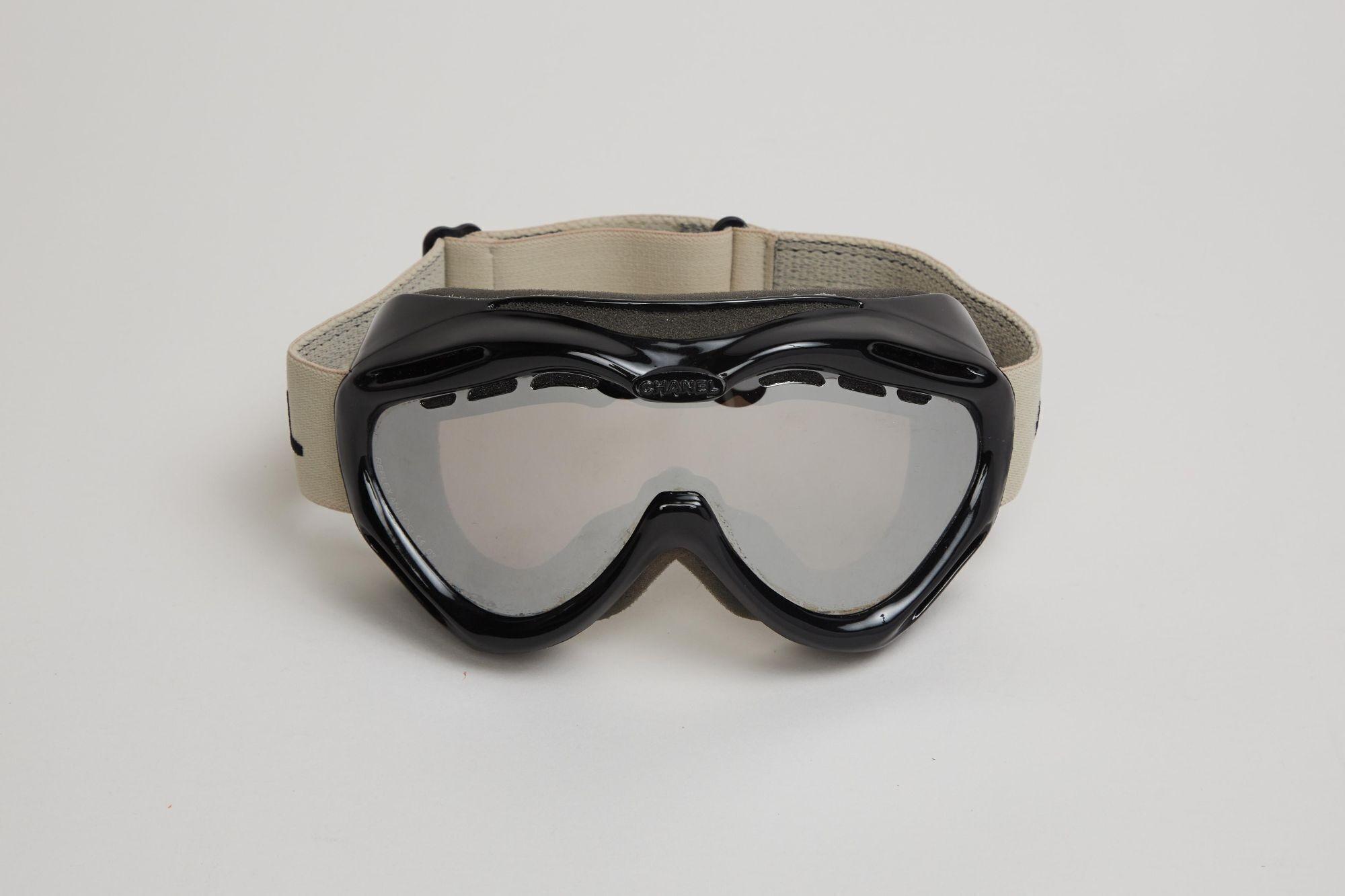 a pair of ski goggles are sitting on a white surface .