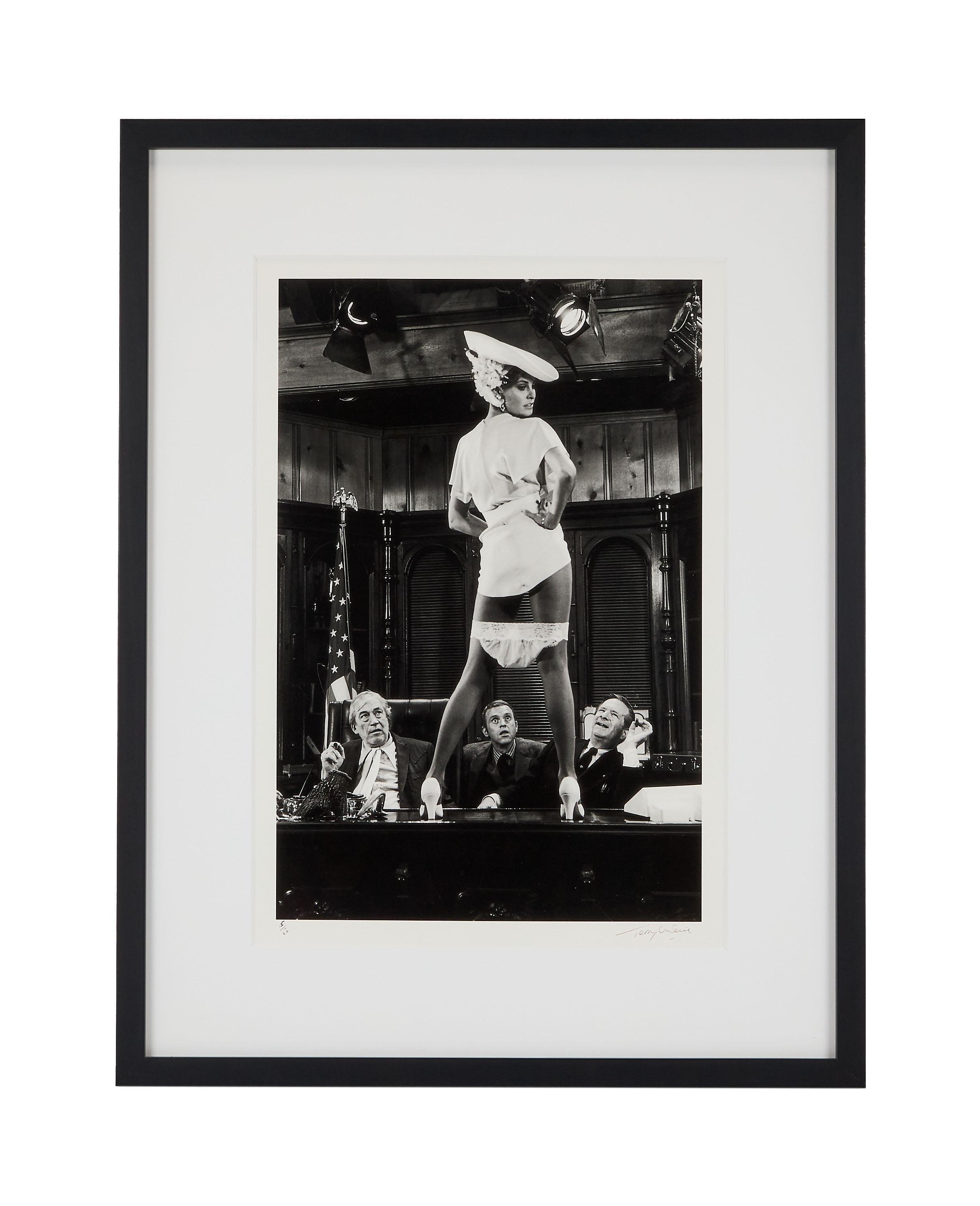 Lot #103. Paul Oakenfold | Raquel Welch Photo by Terry O'Neill a black and white photo of a woman wearing underwear and a hat .