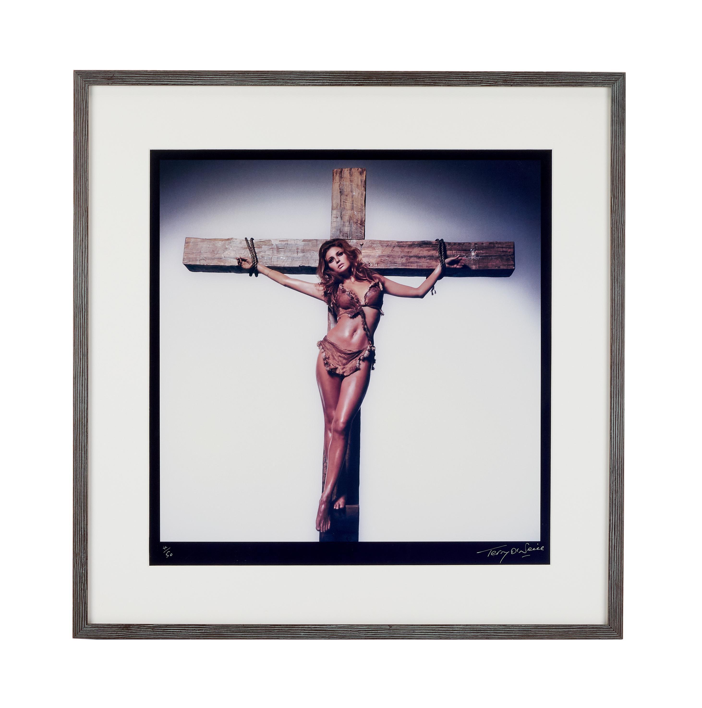 a woman in a bikini is hanging on a cross .