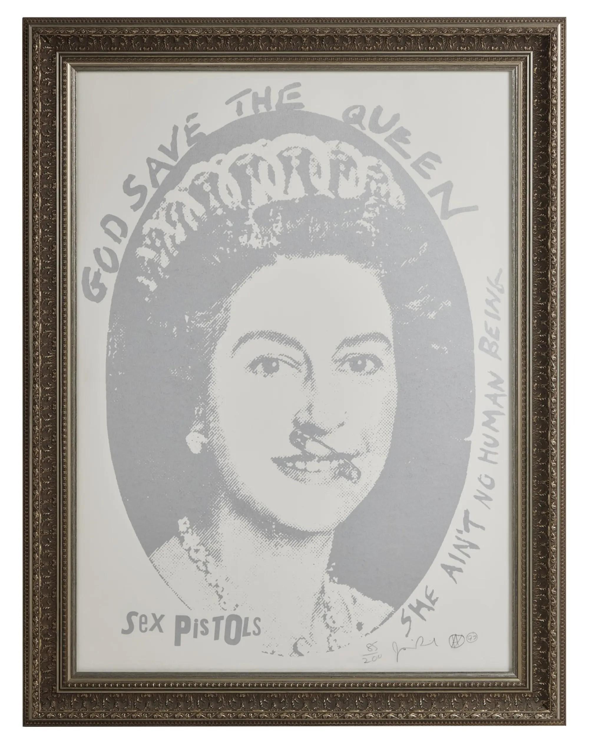 Framed greyscale pop art print of Queen Elizabeth II with a safety pin through her lip, featuring text "GOD SAVE THE QUEEN SHE AIN'T NO HUMAN BEING" and "Sex PISTOLS".