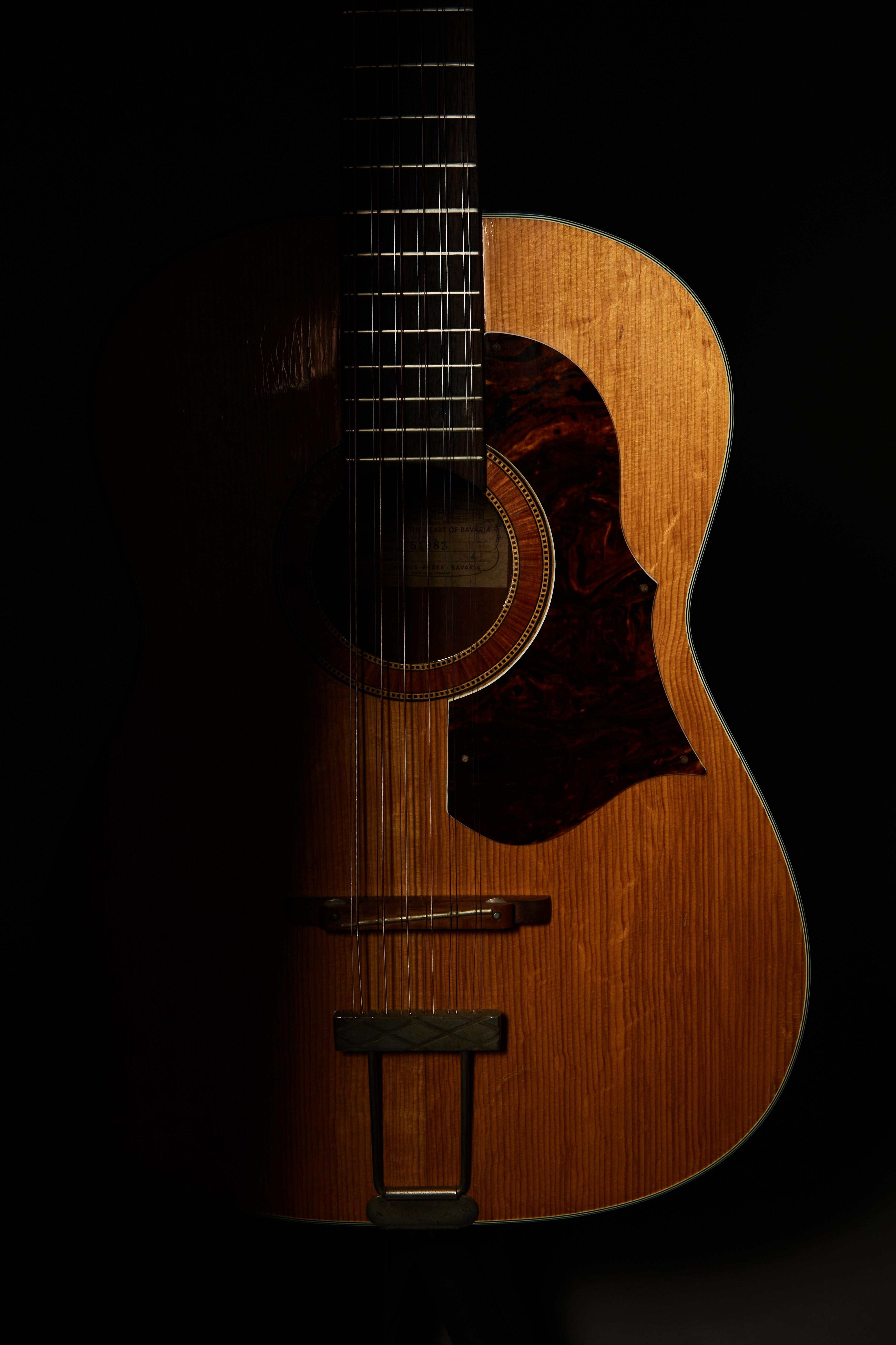 a close up of an acoustic guitar on a black background