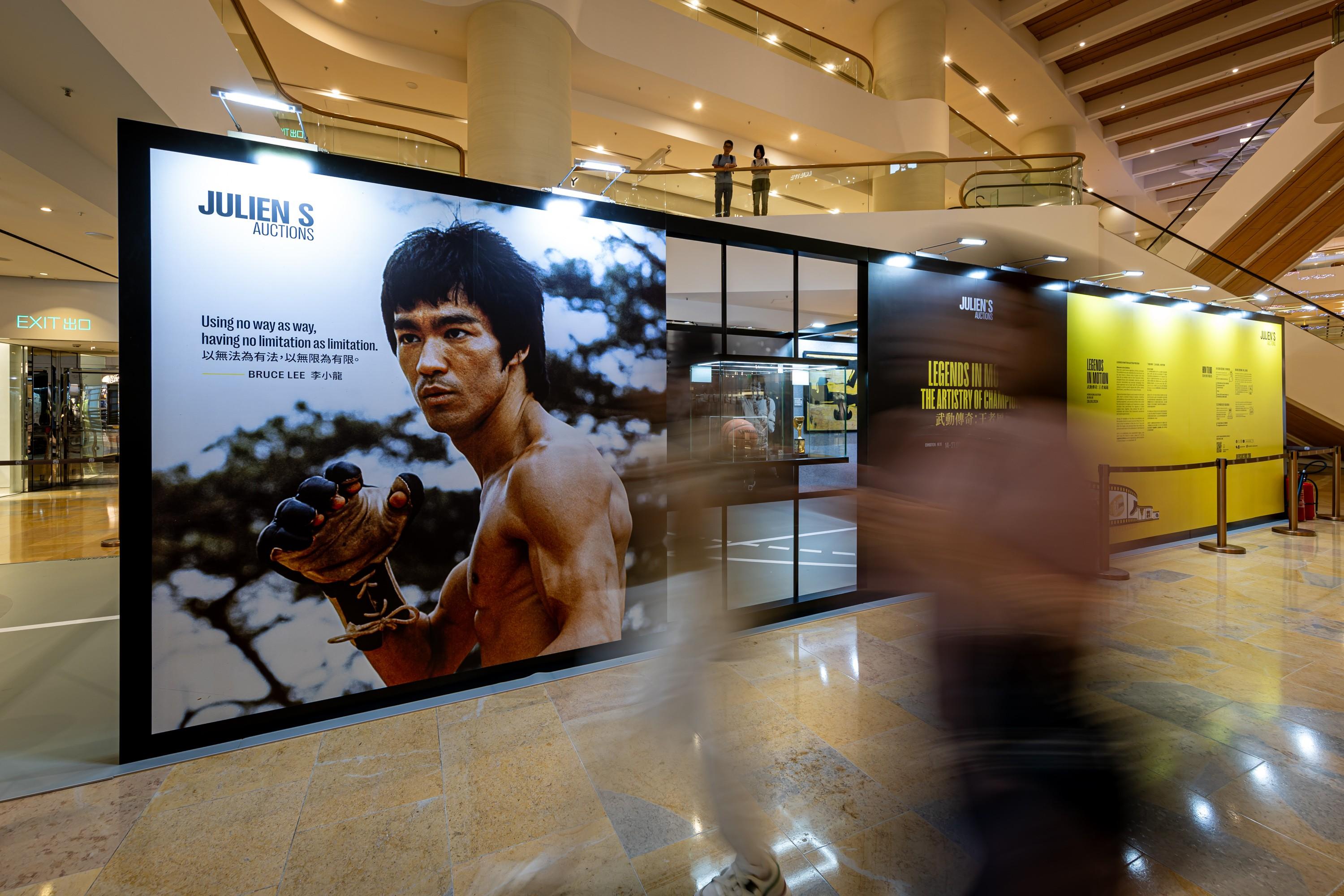 a large billboard with a picture of bruce lee on it in a mall .