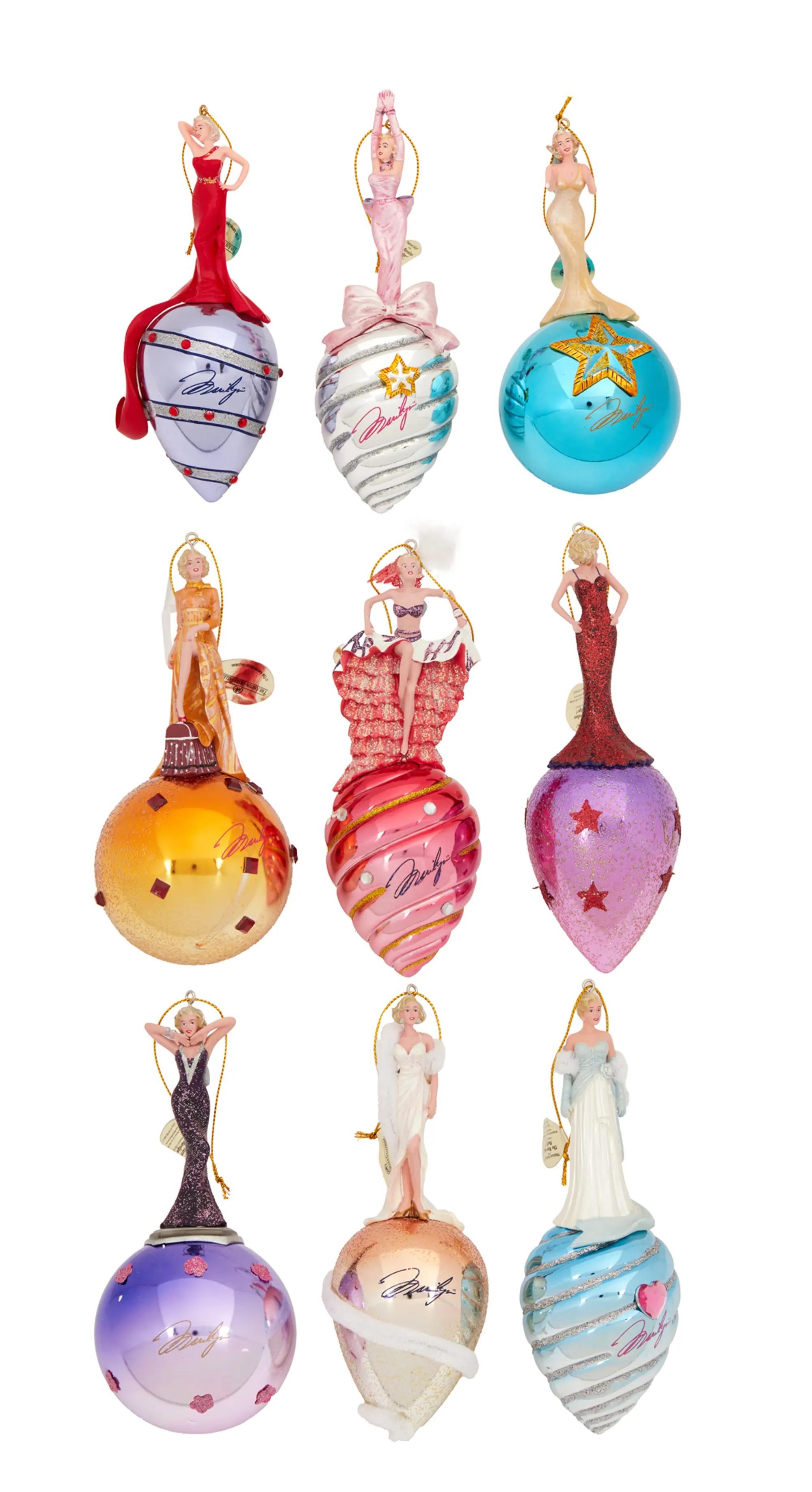 Lot #126. Marilyn Monroe | 2007 Christmas Ornaments by The Ashton-Drake Galleries Nine Marilyn Monroe Christmas ornaments, each featuring a figurine of Marilyn in a famous pose atop a decorated base with her signature.