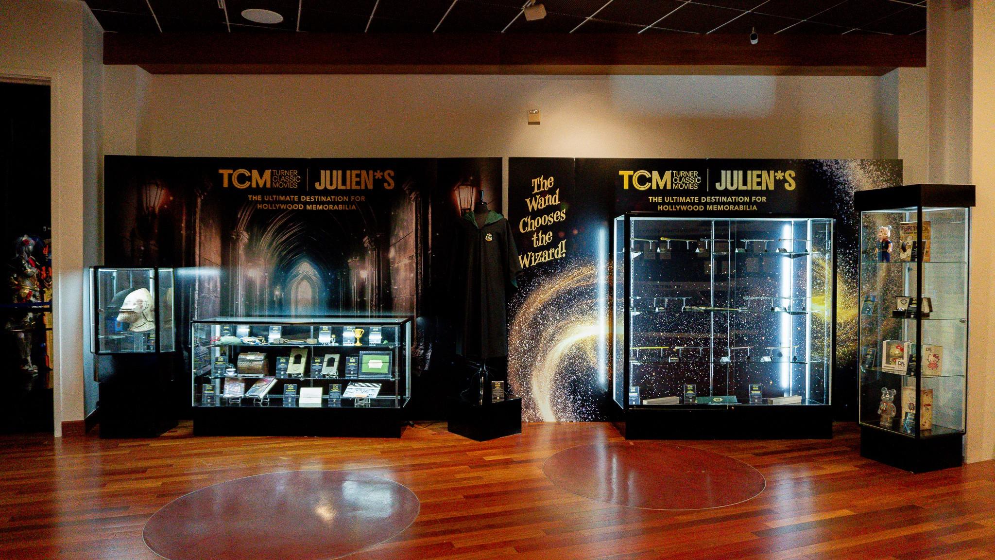 a room with a lot of display cases and a sign that says `` the wind chases the wizard '' .