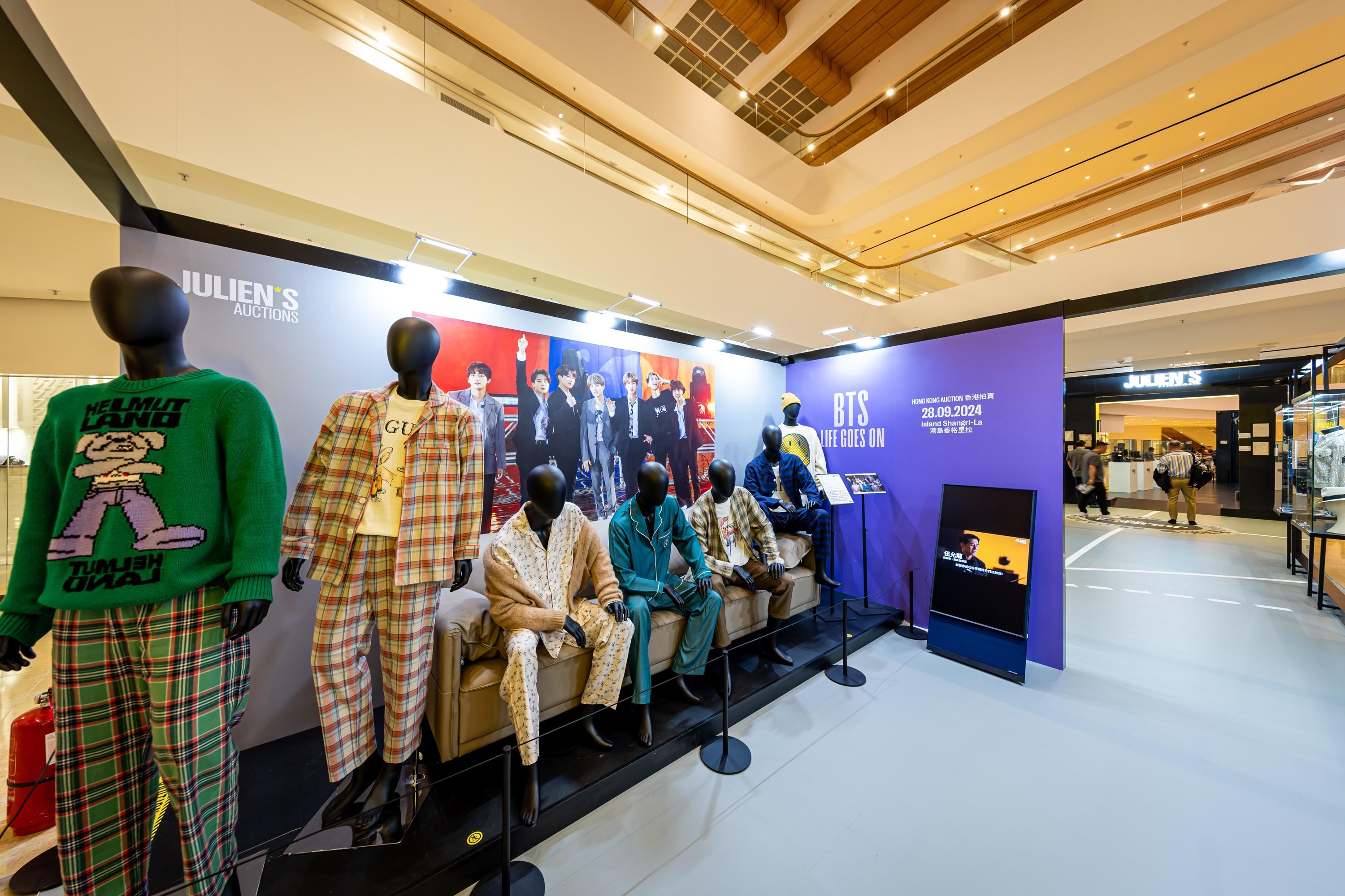 a group of mannequins are sitting on a couch in a store .