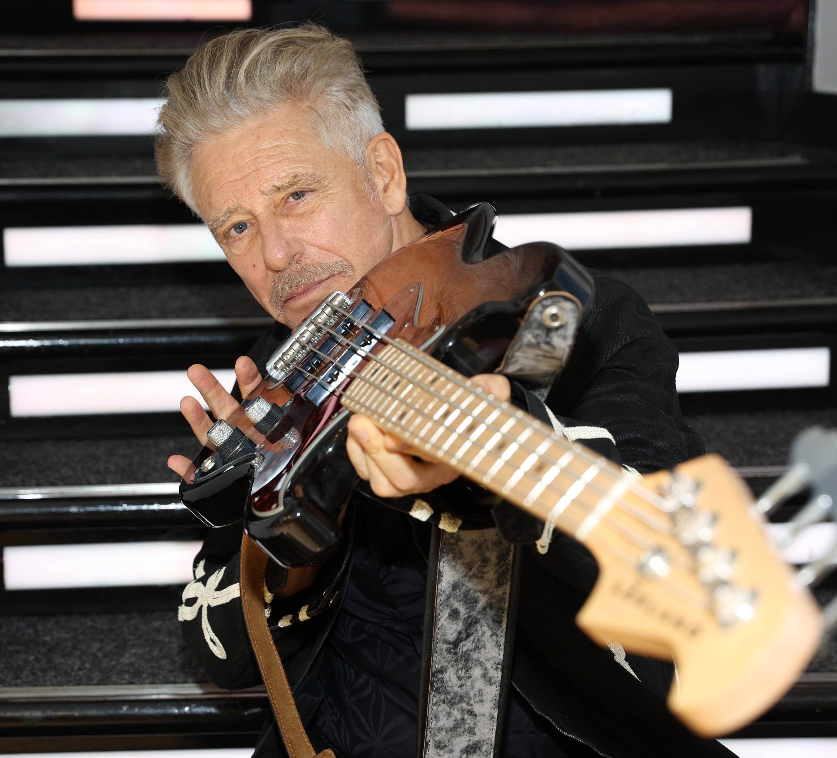 a man holds a black and beige guitar during a photoshoot at the Museum of Style Icons in Newbridge Ireland