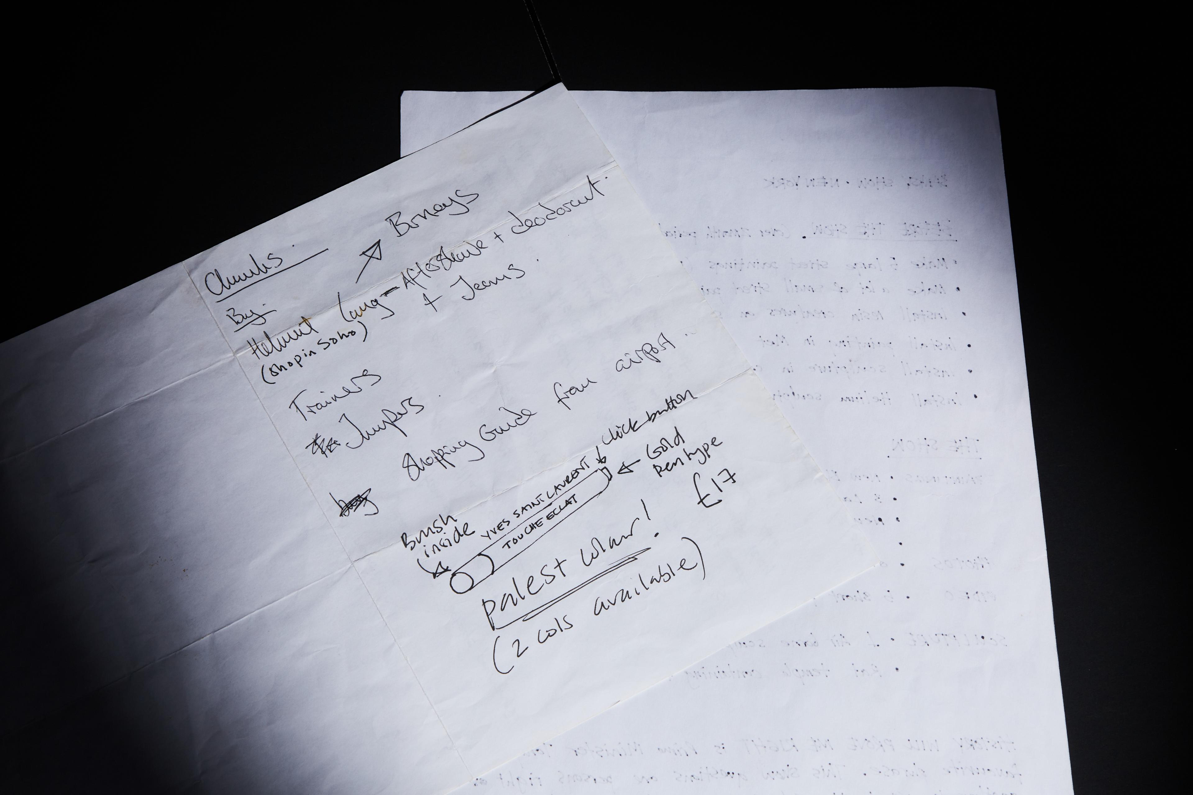 a piece of paper with handwritten notes on it is sitting on top of another piece of paper .
