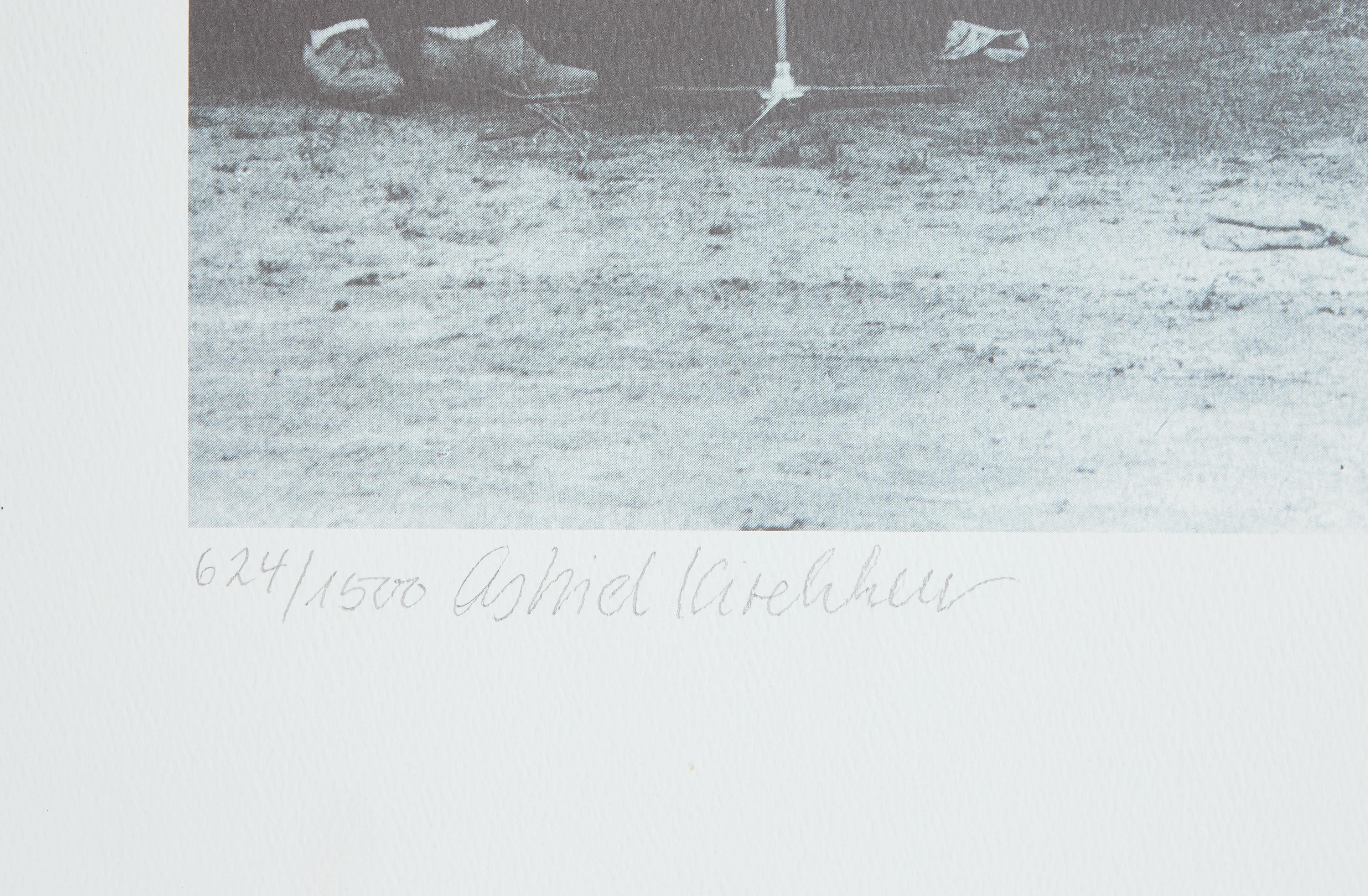 a black and white photo of a person standing in the dirt .
