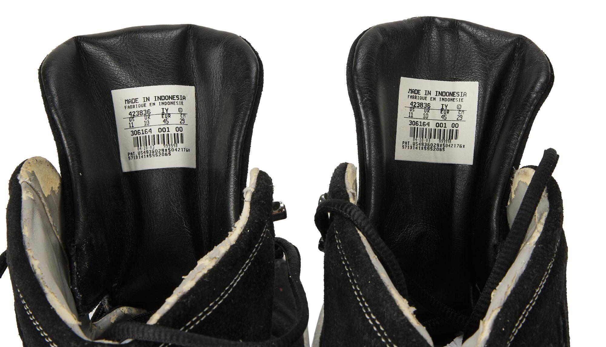 a pair of black nike shoes with a label on the inside of the shoe .